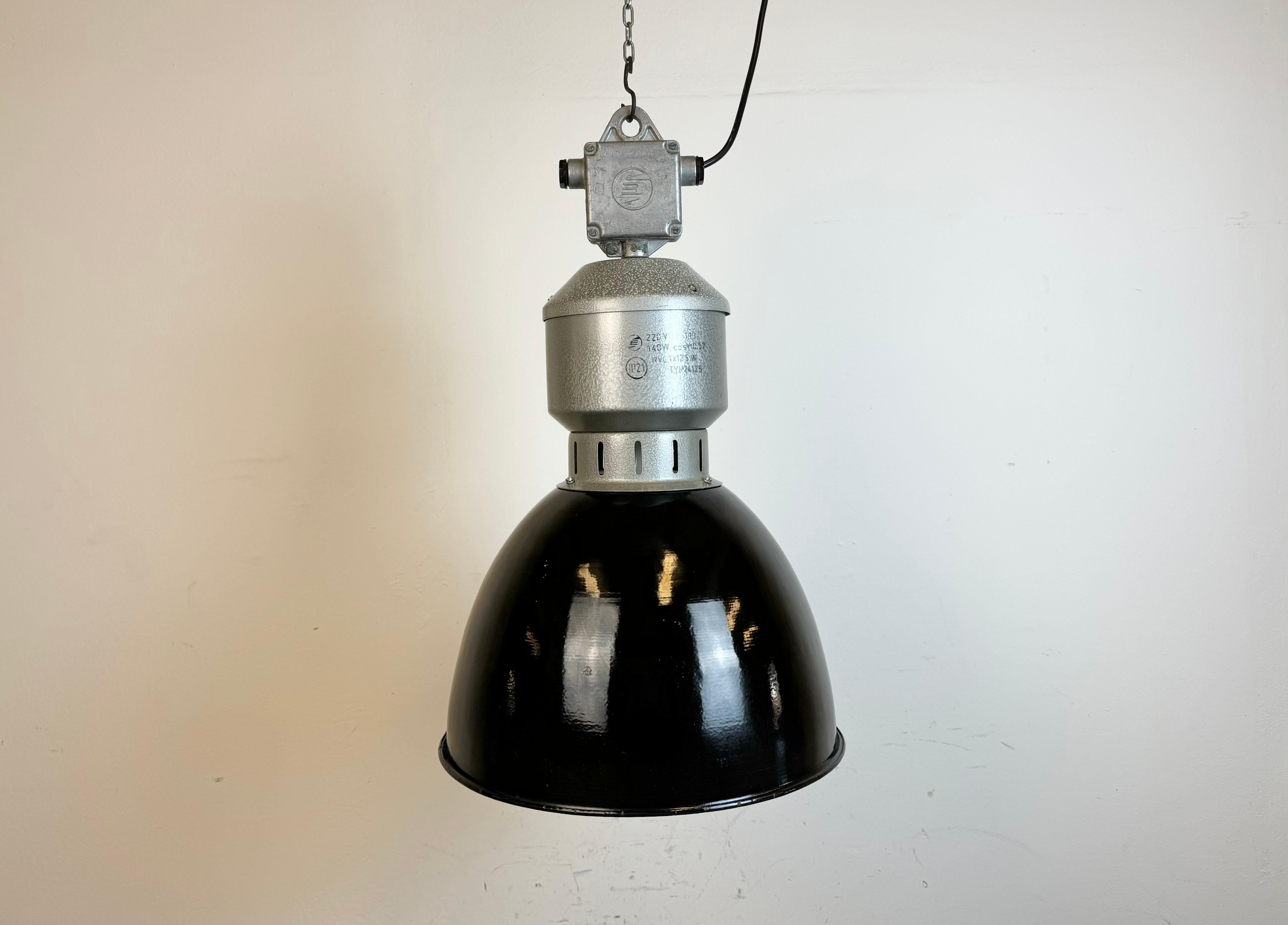 Industrial black enamel pendant light made by Elektrosvit in former Czechoslovakia during the 1960s. White enamel inside the shade. Iron hammerpaint neck with cast aluminium top box. The porcelain socket requires standard E 27/ E26 light bulbs. New