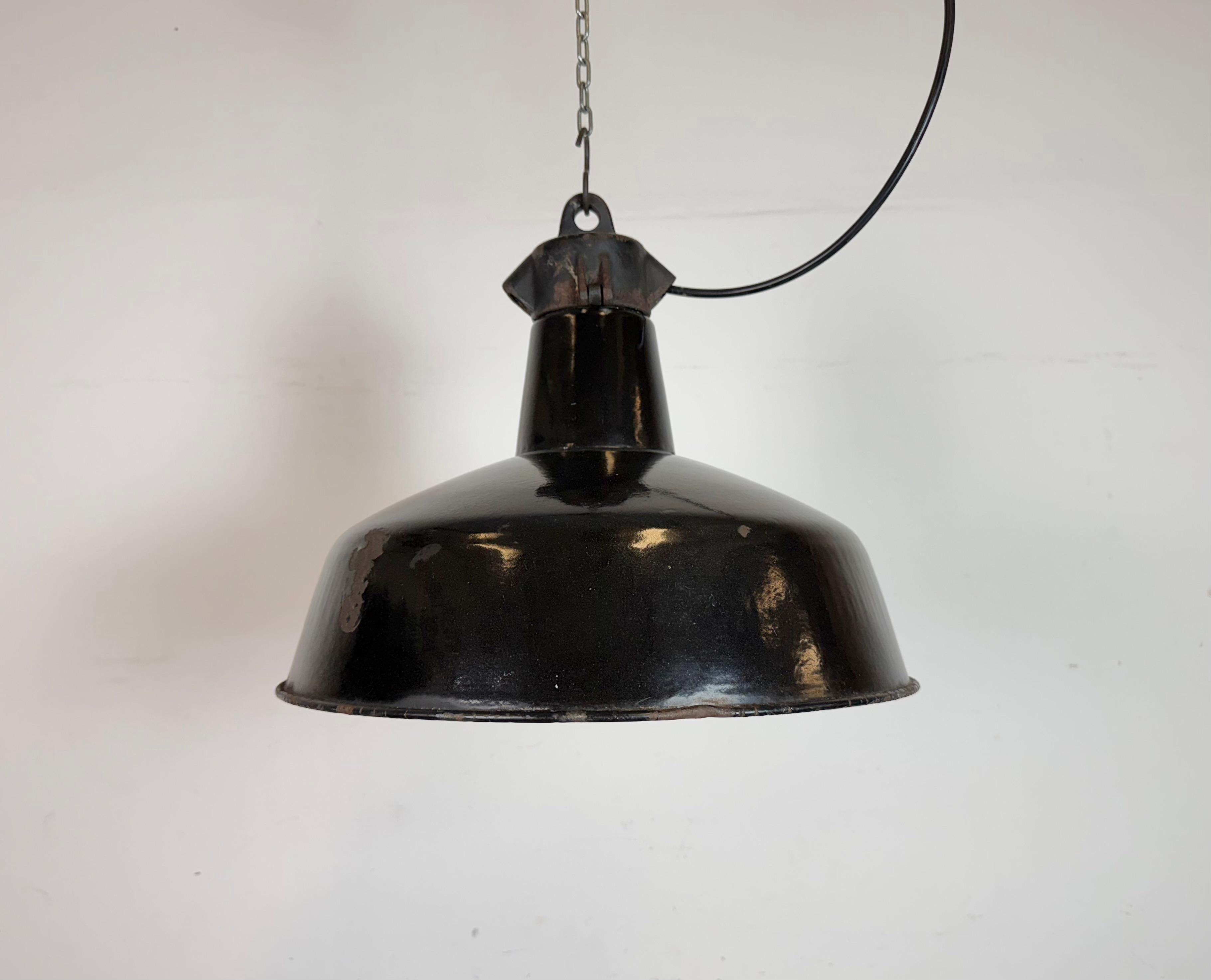Industrial black enamel pendant light made by Elektrosvit in former Czechoslovakia during the 1950s. White enamel inside the shade. Cast iron top. The porcelain socket requires standard E 27/ E26 light bulbs. New wire. Fully functional. The weight