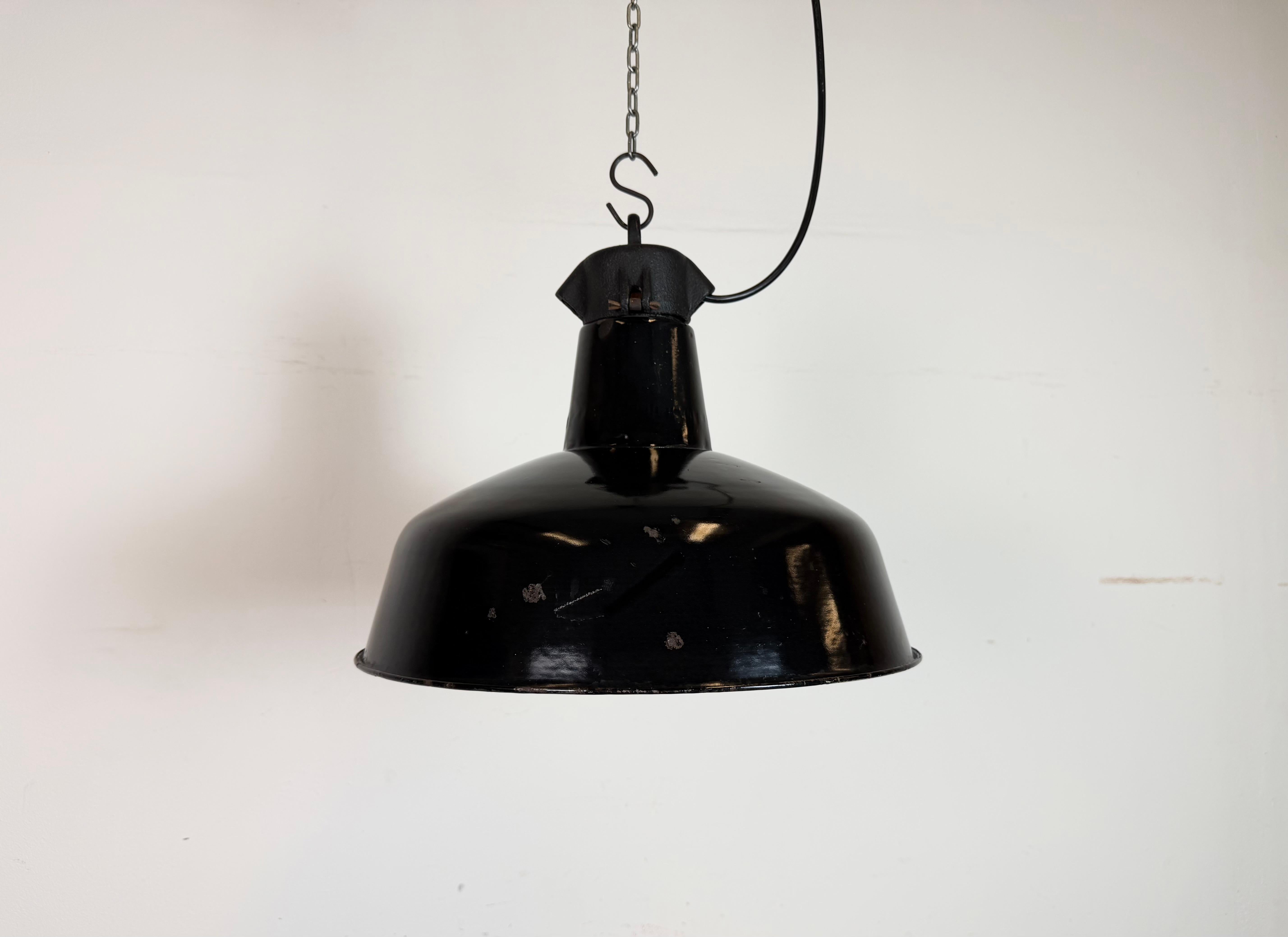 Industrial black enamel pendant light made by Elektrosvit in former Czechoslovakia during the 1950s. White enamel inside the shade. Cast iron top. The porcelain socket requires standard E 27/ E26 light bulbs. New wire. Fully functional. The weight