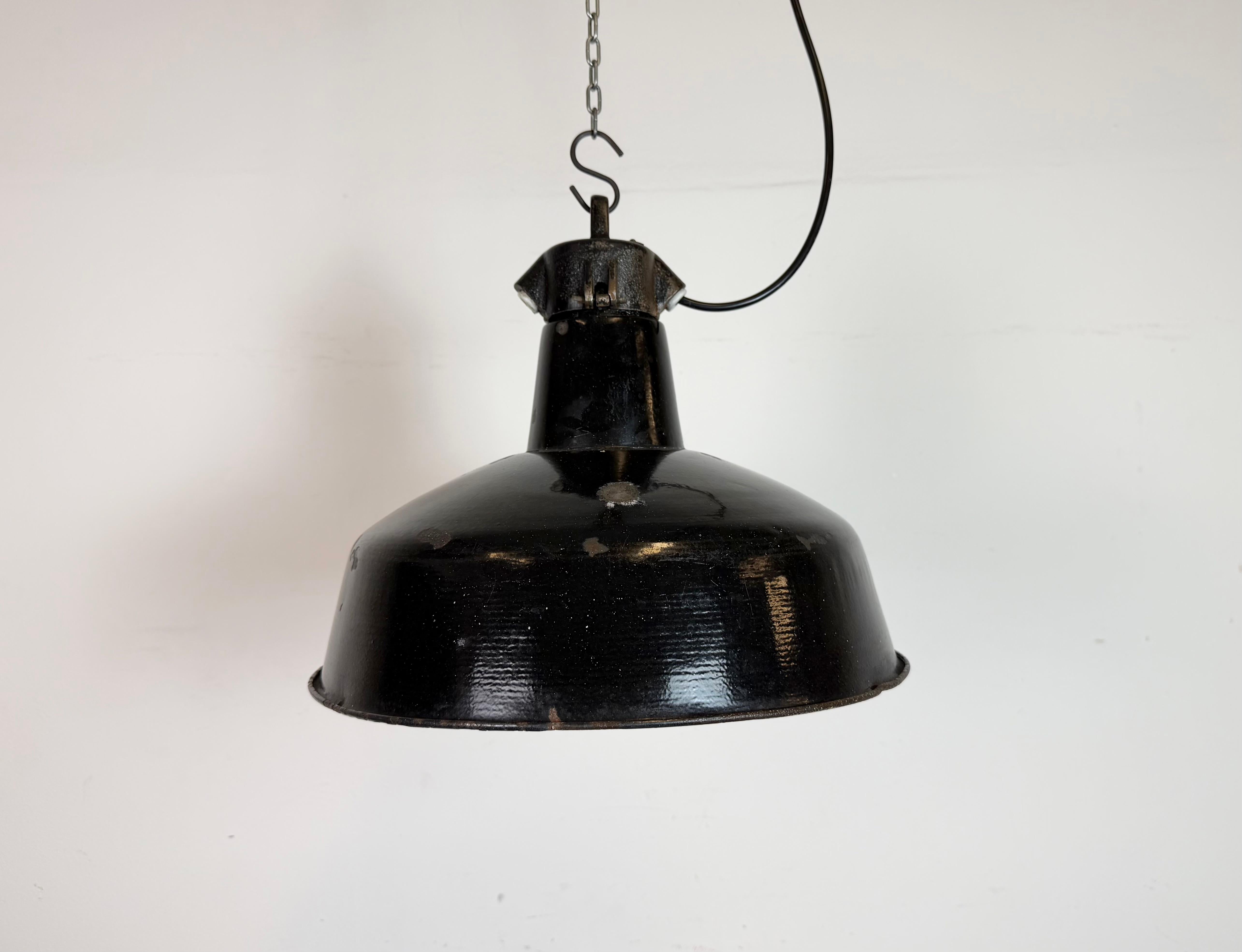 Industrial black enamel pendant light made by Elektrosvit in former Czechoslovakia during the 1950s. White enamel inside the shade. Cast iron top. The porcelain socket requires standard E 27/ E26 light bulbs. New wire. Fully functional. The weight