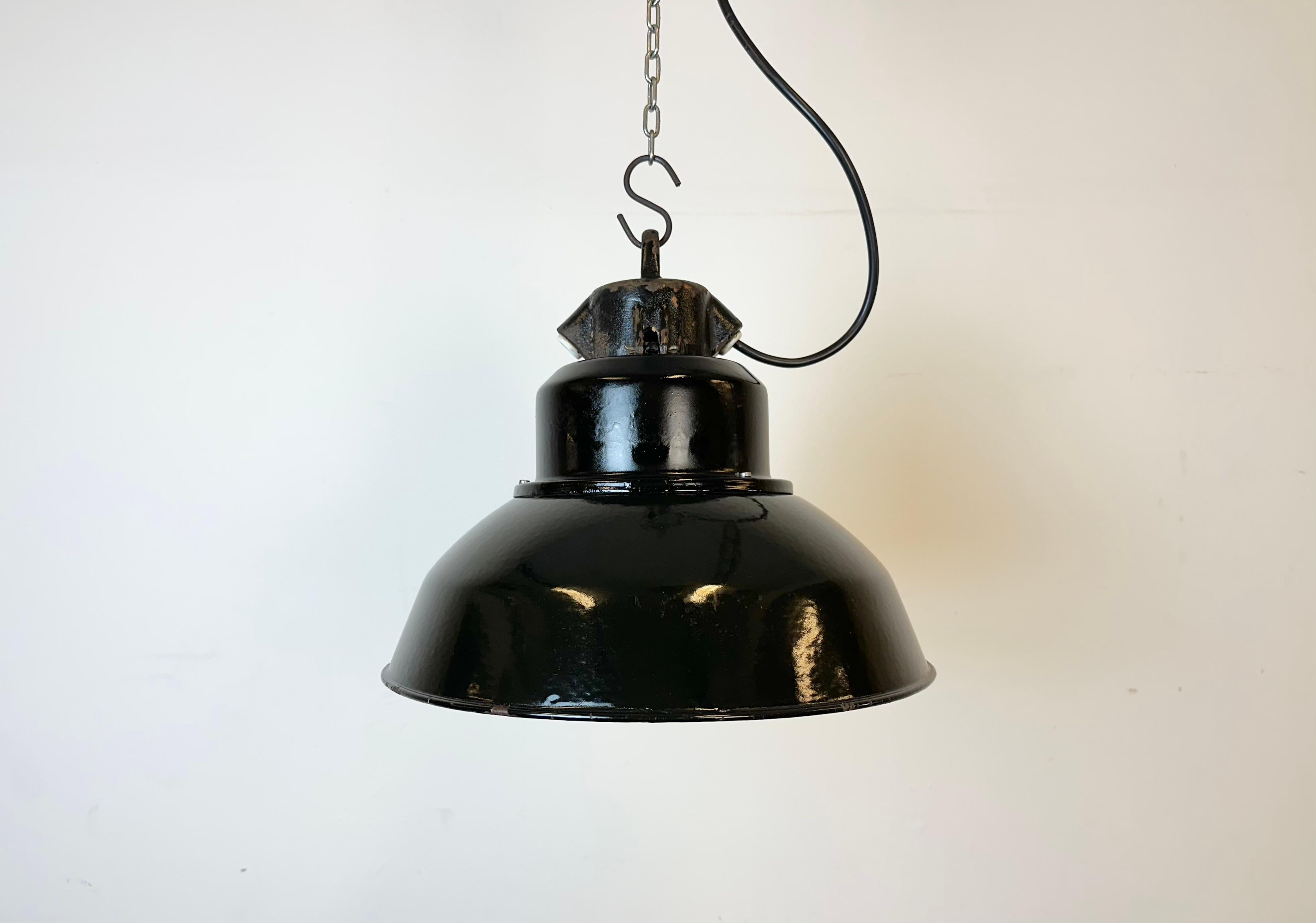 Industrial black enamel pendant light made by Elektrosvit in former Czechoslovakia during the 1960s. White enamel inside the shade. Cast iron top. The porcelain socket requires E 27/ E26 light bulbs. New wire. Fully functional. The weight of the