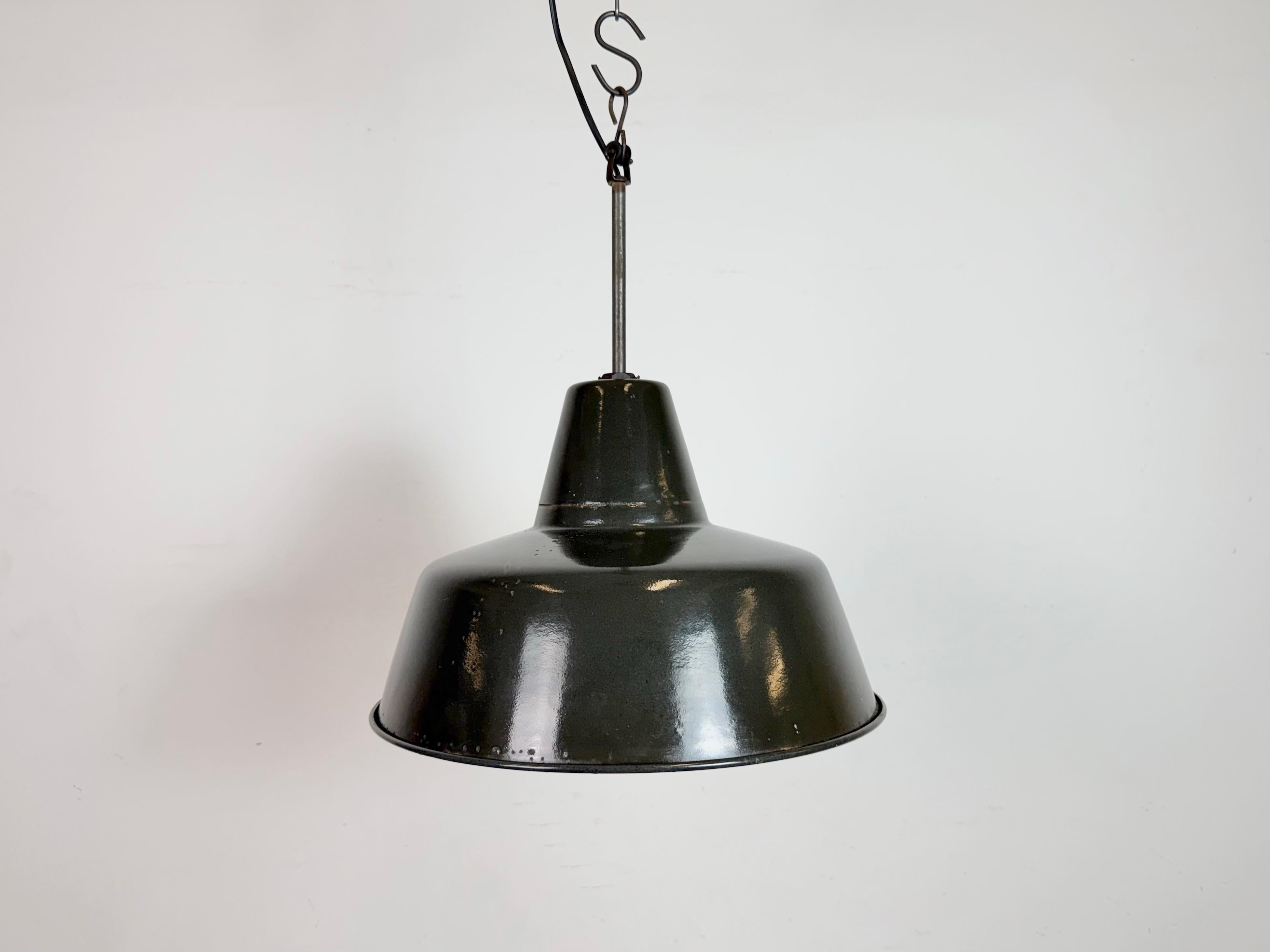 Industrial black enamel pendant light made in Germany during the 1950s. White enamel inside the shade. Iron top. The socket requires standard E27/ E26 light bulbs. New wire. Fully functional. The weight of the lamp is 1,5 kg.The diameter of the