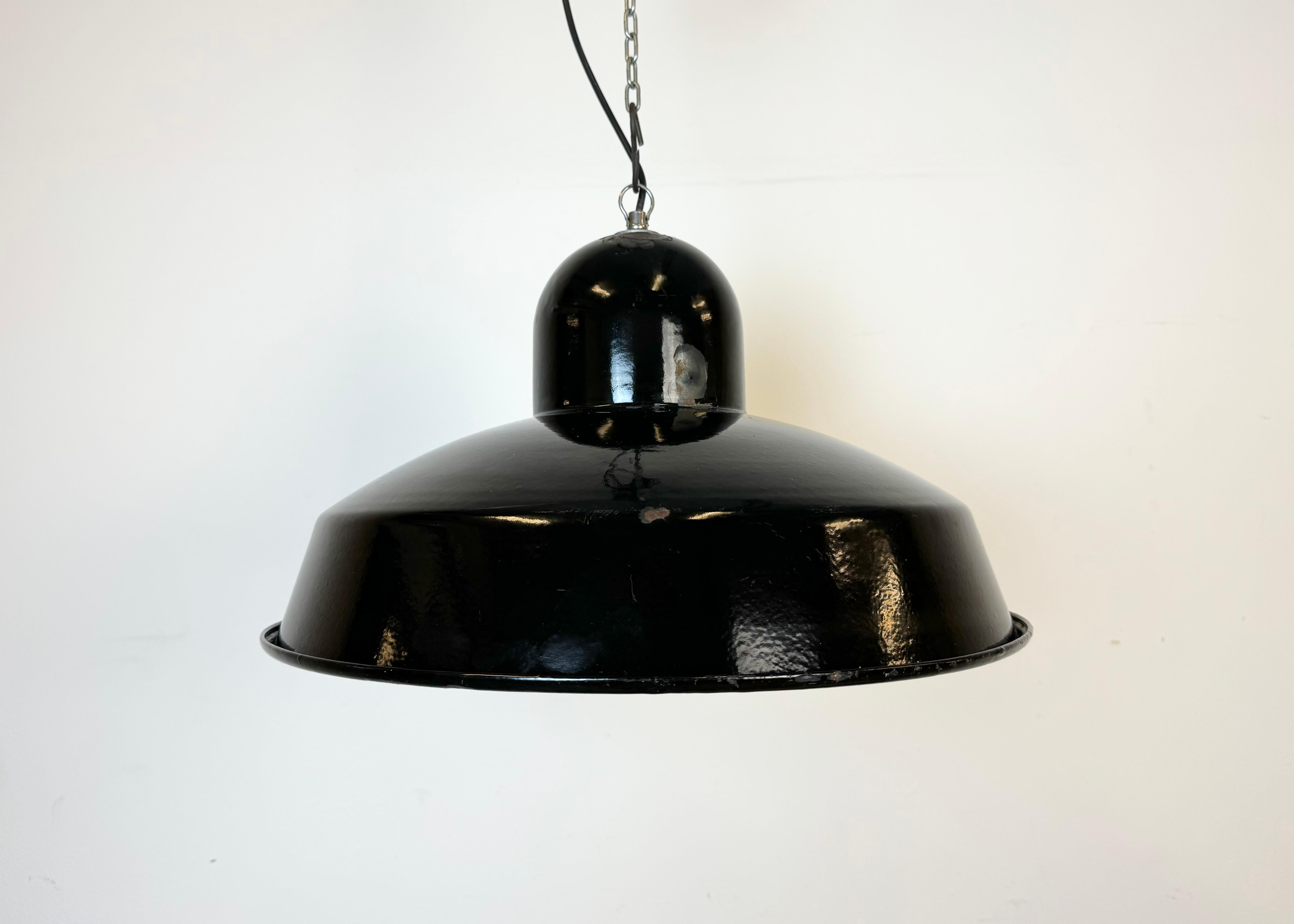 Industrial factory hanging lamp made in Portugal during the 1960s. It features a black enamel shade with white enamel interior and an iron top. New  socket requires standard E 27/ E 26 light bulbs. New wire. The lamp weighs 2 kg. The lampshade