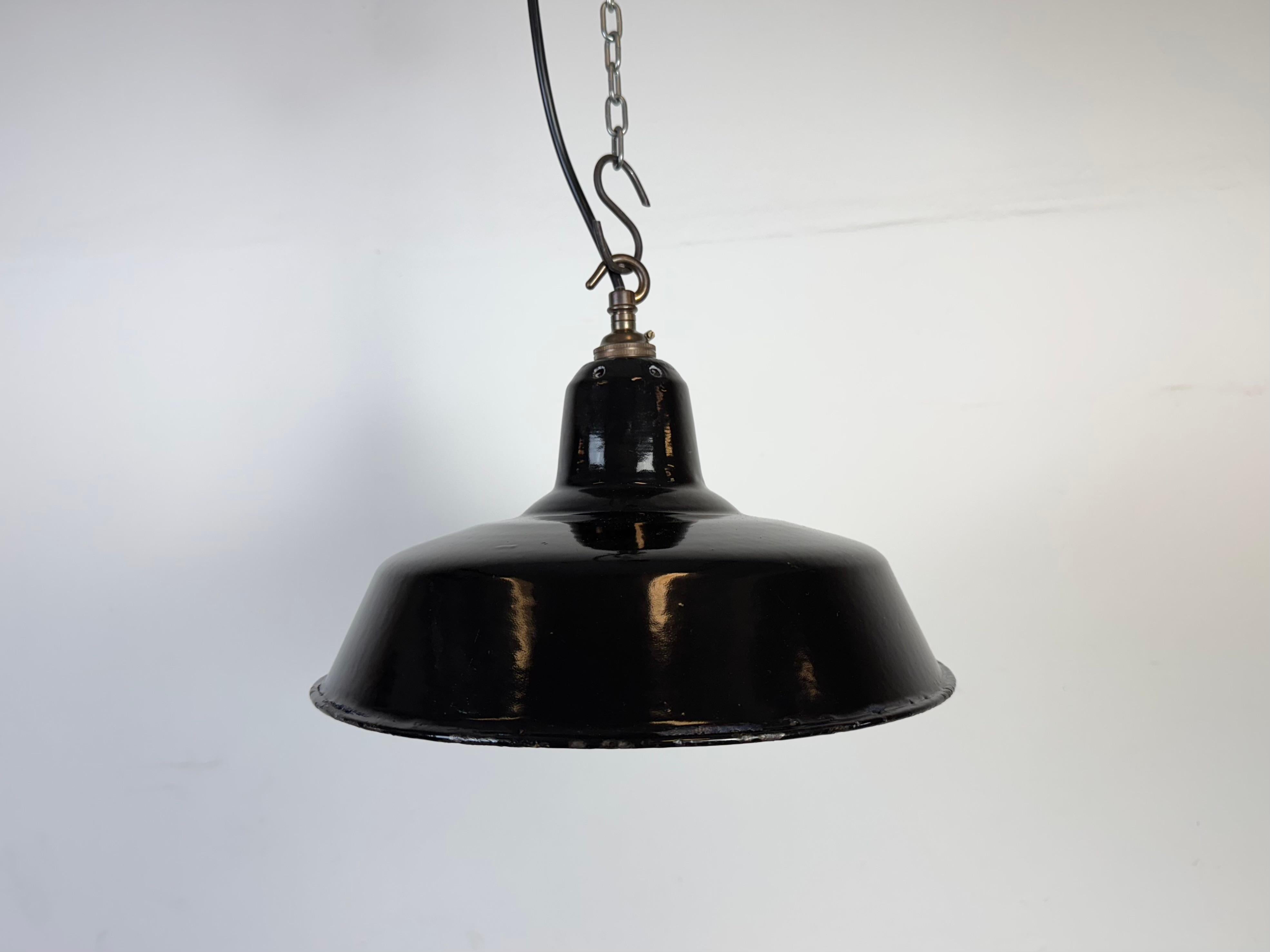 Industrial black enamel pendant light made in United Kingdom during the 1960s. White enamel inside the shade. Brass top. The socket requires B22 light bulbs. New wire. The weight of the lamp is 0,9 kg.The diameter of the shade is 30 cm.