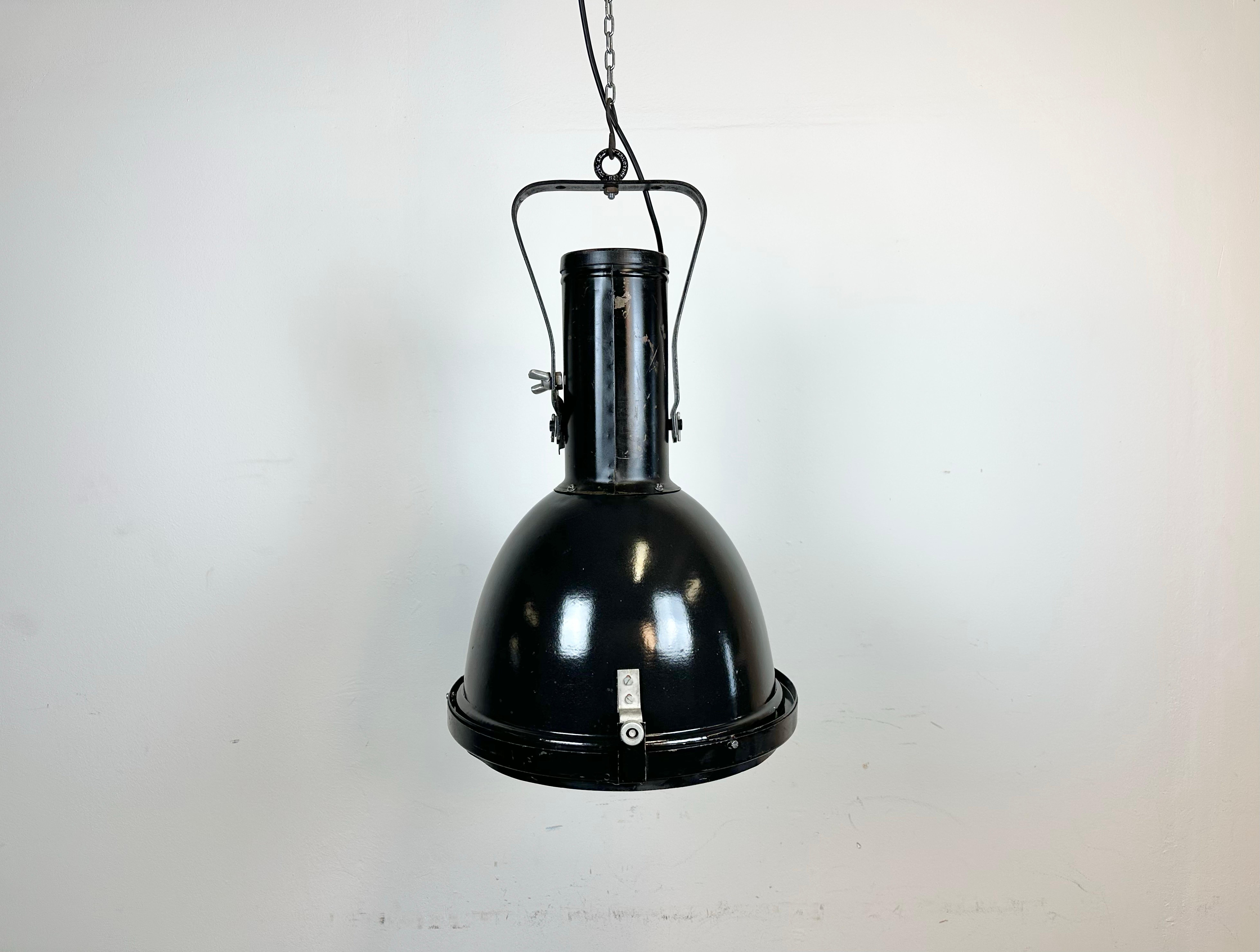 - Vintage factory spotlight made by Elektrosvit in former Czechoslovakia during the 1960s/70s
- It features a black enamel lampshade with white enamel interior, an iron top and convex clear glass cover
- The porcelain socket requires E27/ E26
