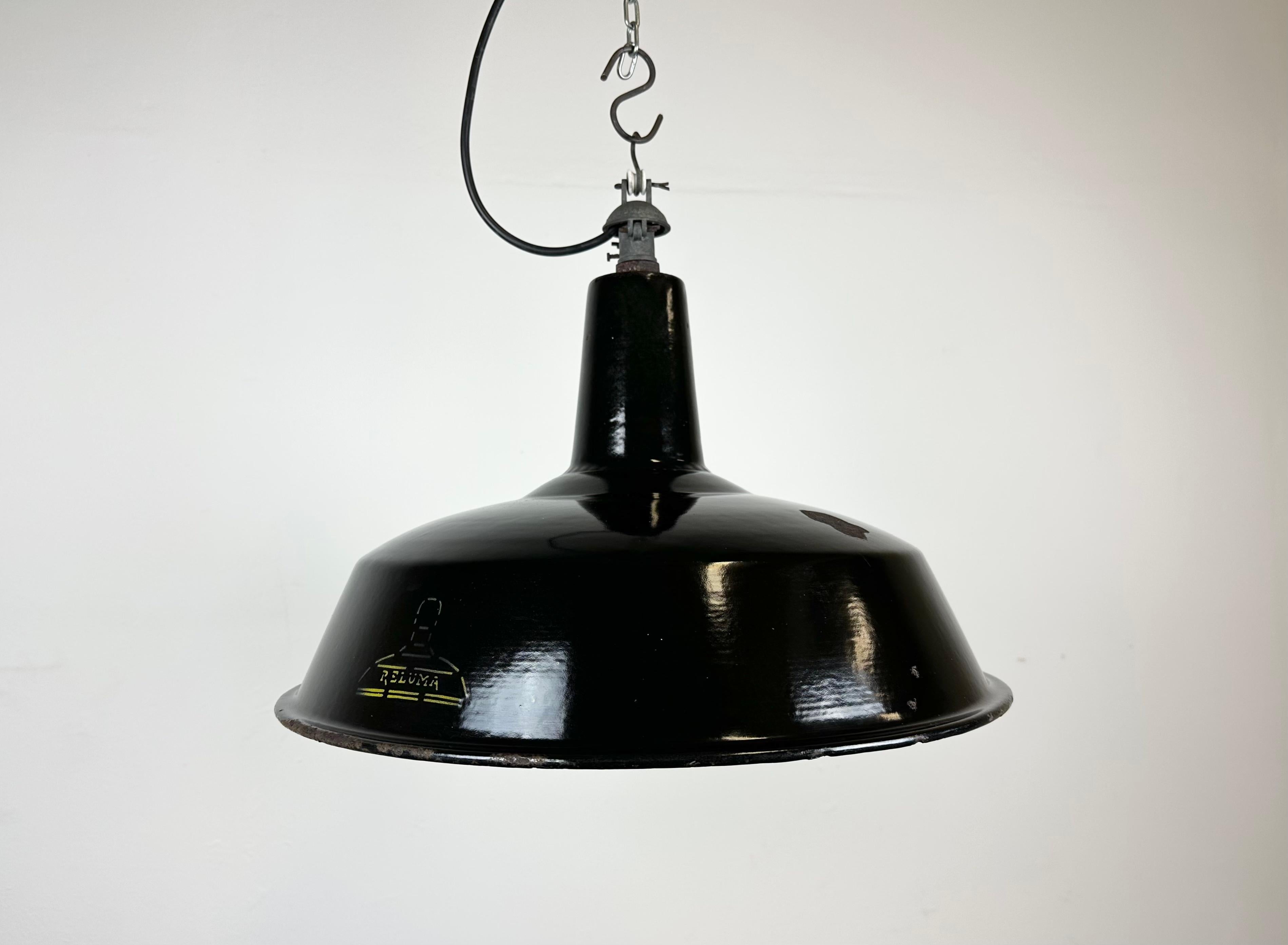Industrial pendant light made in Belgium by Reluma during the 1950s. Made from enamelled metal. Black outside, white interior. Interesting iron top. New porcelain socket requires E 27/ E 26 light bulbs. New wire. The weight of the lamp is 1,5kg.