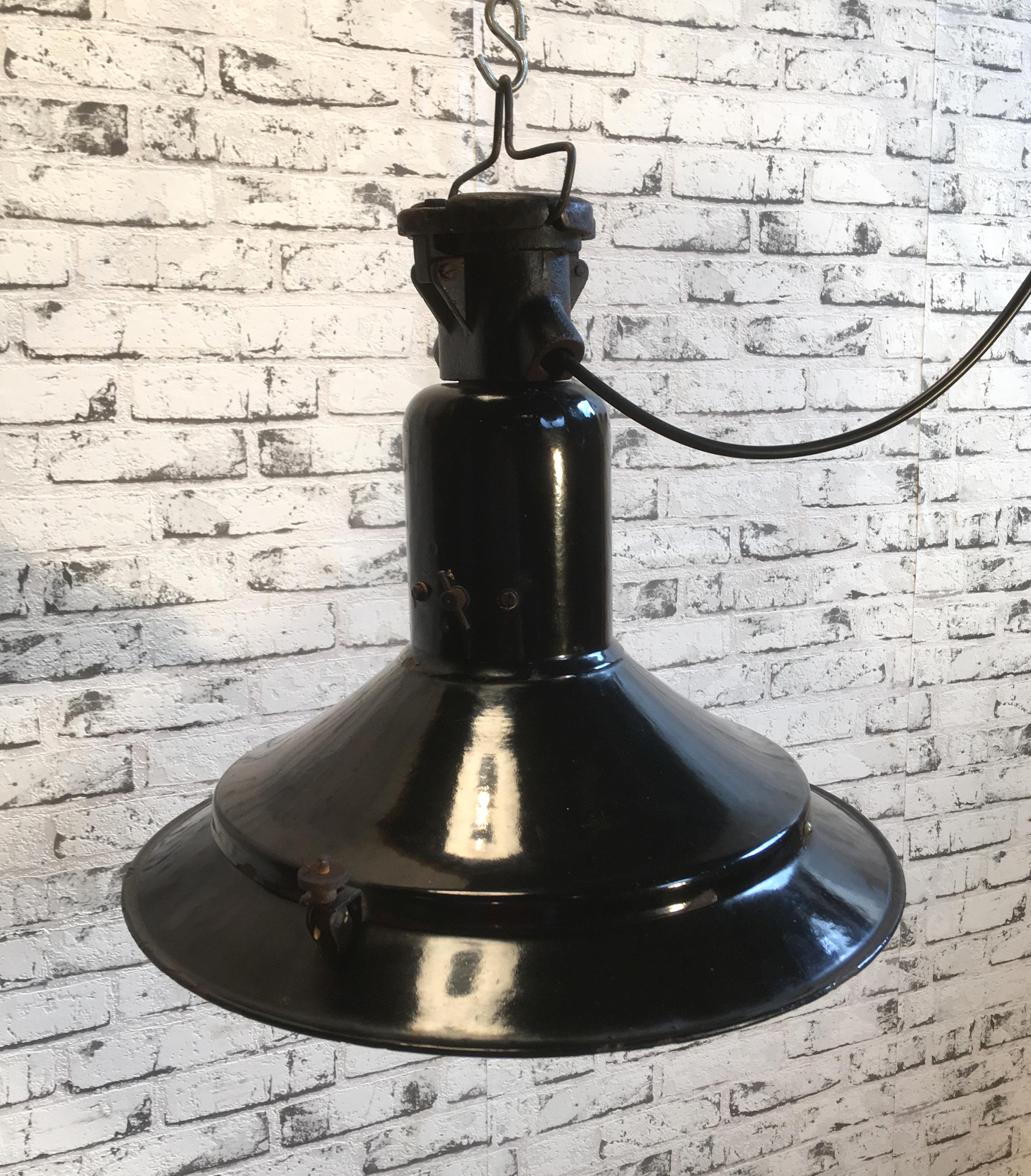 This very old Industrial lamp comes from the 1920s.It has black enamel exterior, white interior. Cast iron top. New porcelain socket E 27 and wire. Weight 5 kg.