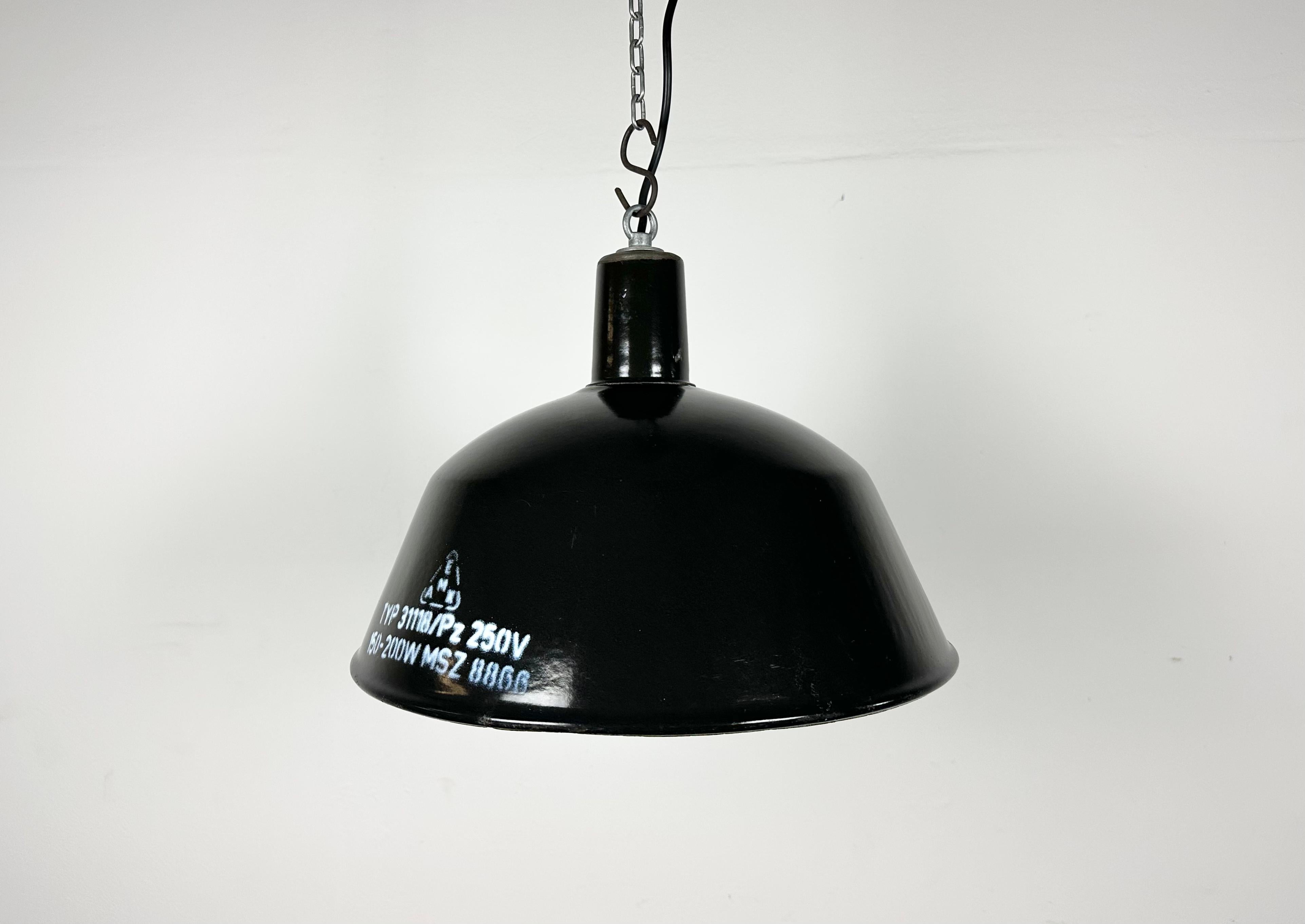 This industrial lamp was made by EMAX in Hungary during the 1960s. It features a black enamel shade with white enamel interior and iron top. New porcelain socket requires E 27/ E26 light bulbs. New wire. The weight of the lamp is 1,5 kg.