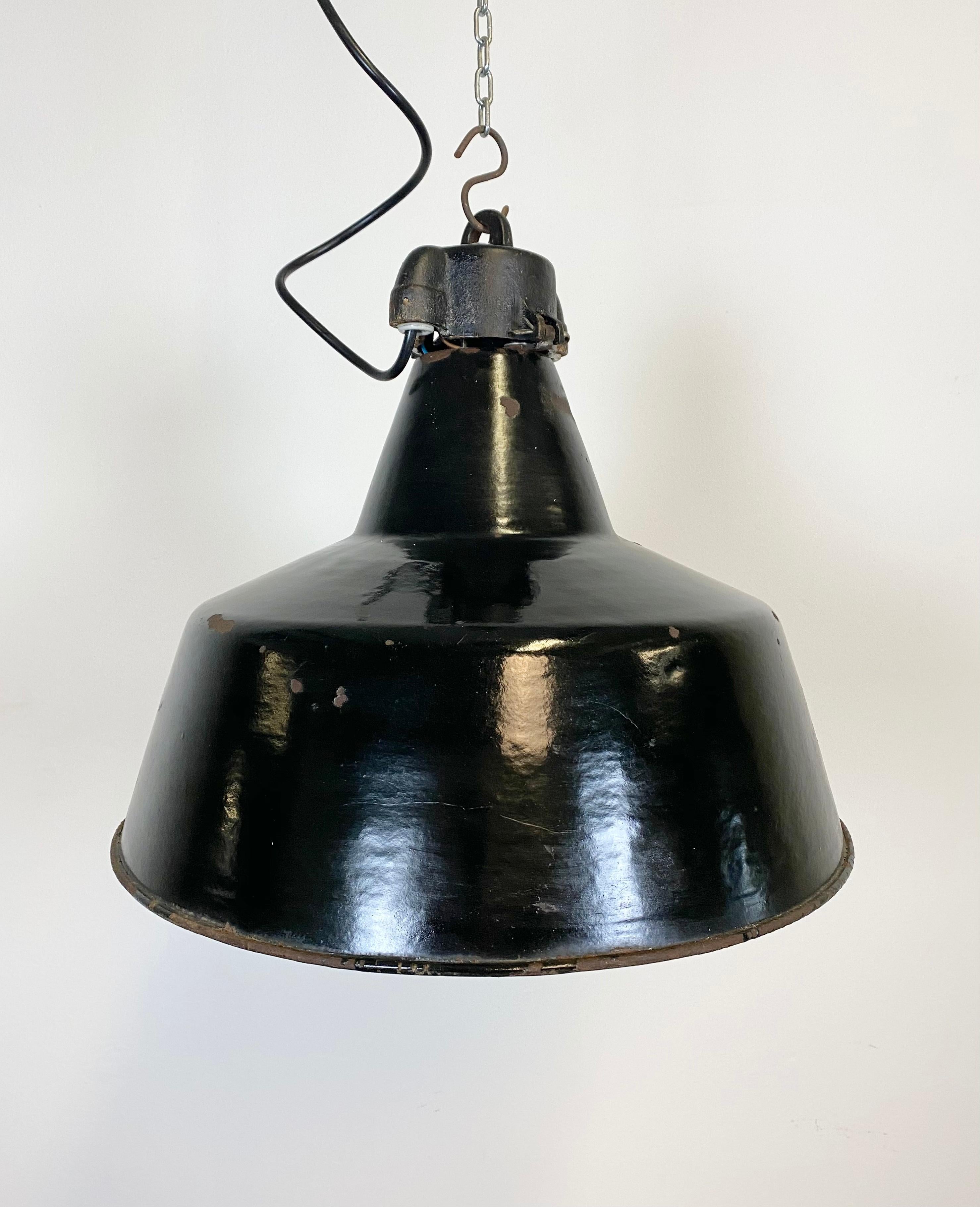 Vintage Industrial black enamel lamp made by Elektrosvit in former Czechoslovakia during the 1970s. White enamel interior. Cast iron top. New porcelain socket for E 27 lightbulbs and wire. The weight of the lamp is 2.5 kg.
