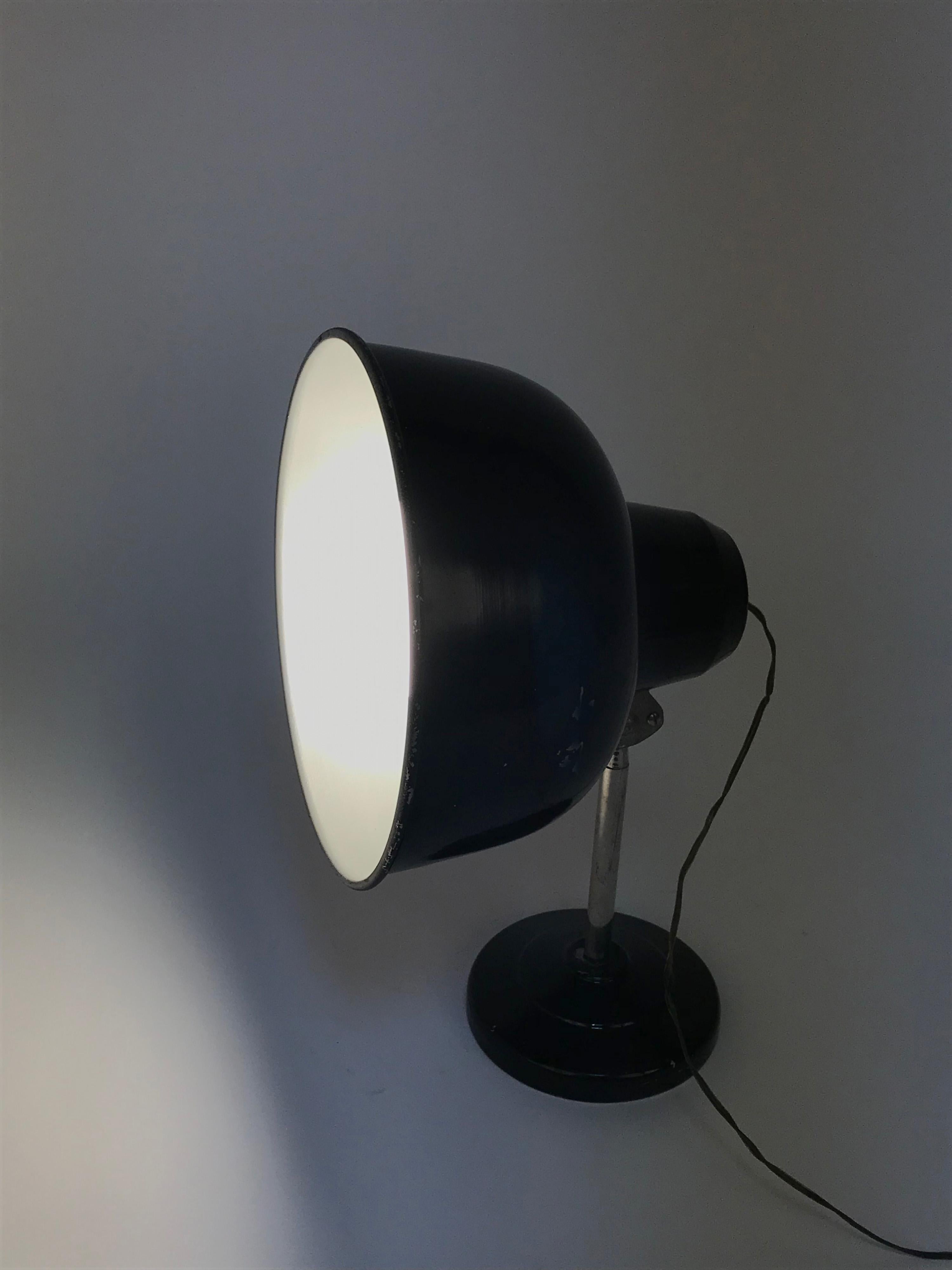 Amazing midcentury industrial black enamelled metal adjustable table desk lamp. This fantastic item was designed in Italy during the 1940s.

This marvellous lamp has its original bulb from the 1940s at 125 volts. Works with 250-volt bulbs, but