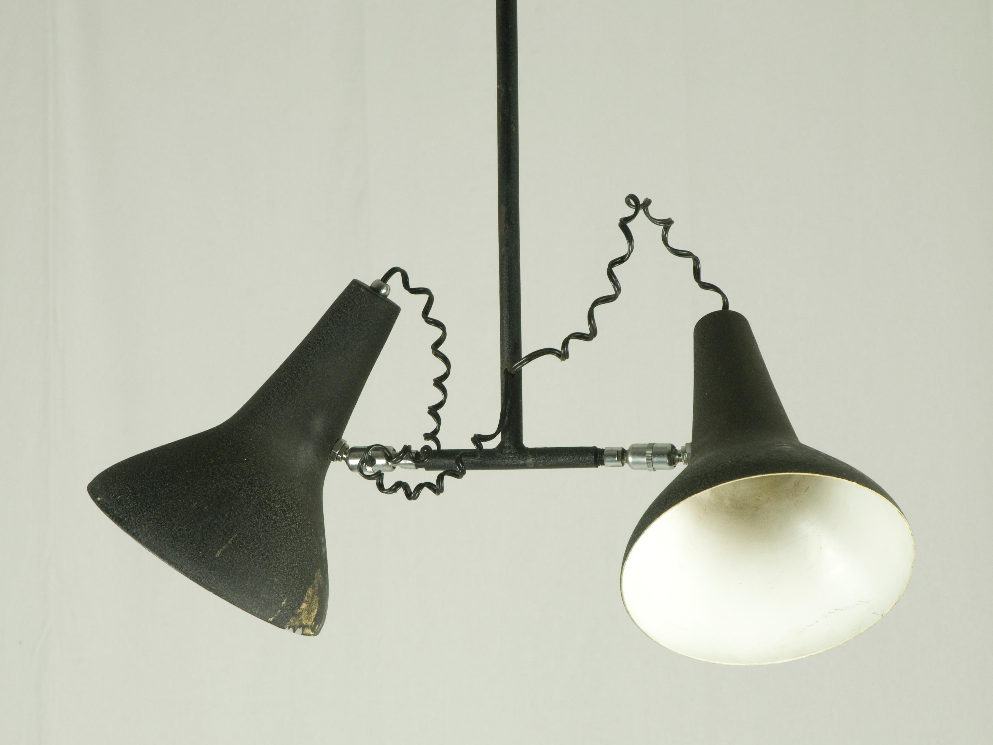 This Industrial pendant lamp was produced around the 1950s. It is made from a metal structure with a black 