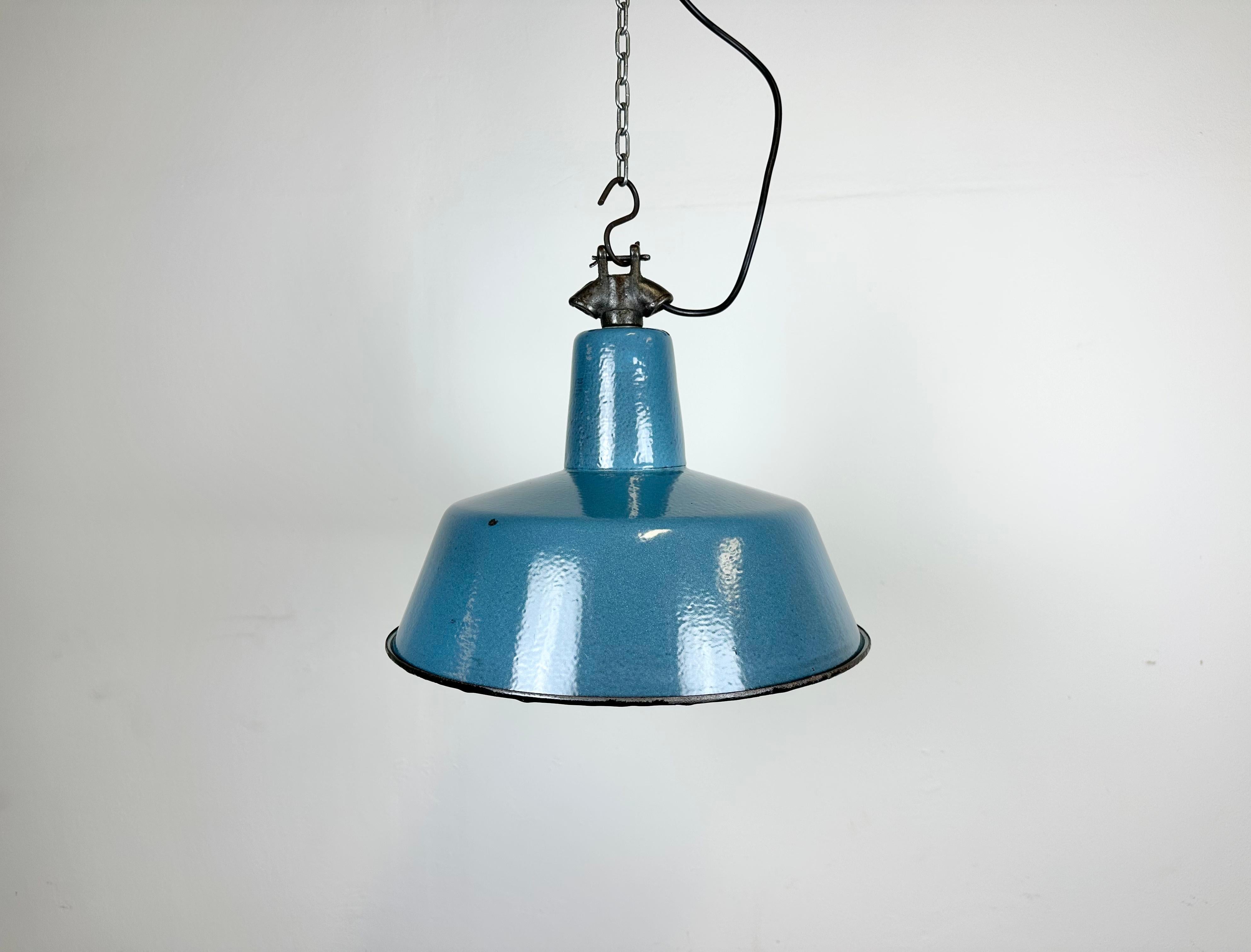 Industrial blue enamel pendant light made by Polam Wilkasy in Poland during the 1960s. White enamel inside the shade. Cast iron top. The porcelain socket requires E 27/ E 26 light bulbs. New wire. The weight of the lamp is 1,5 kg.