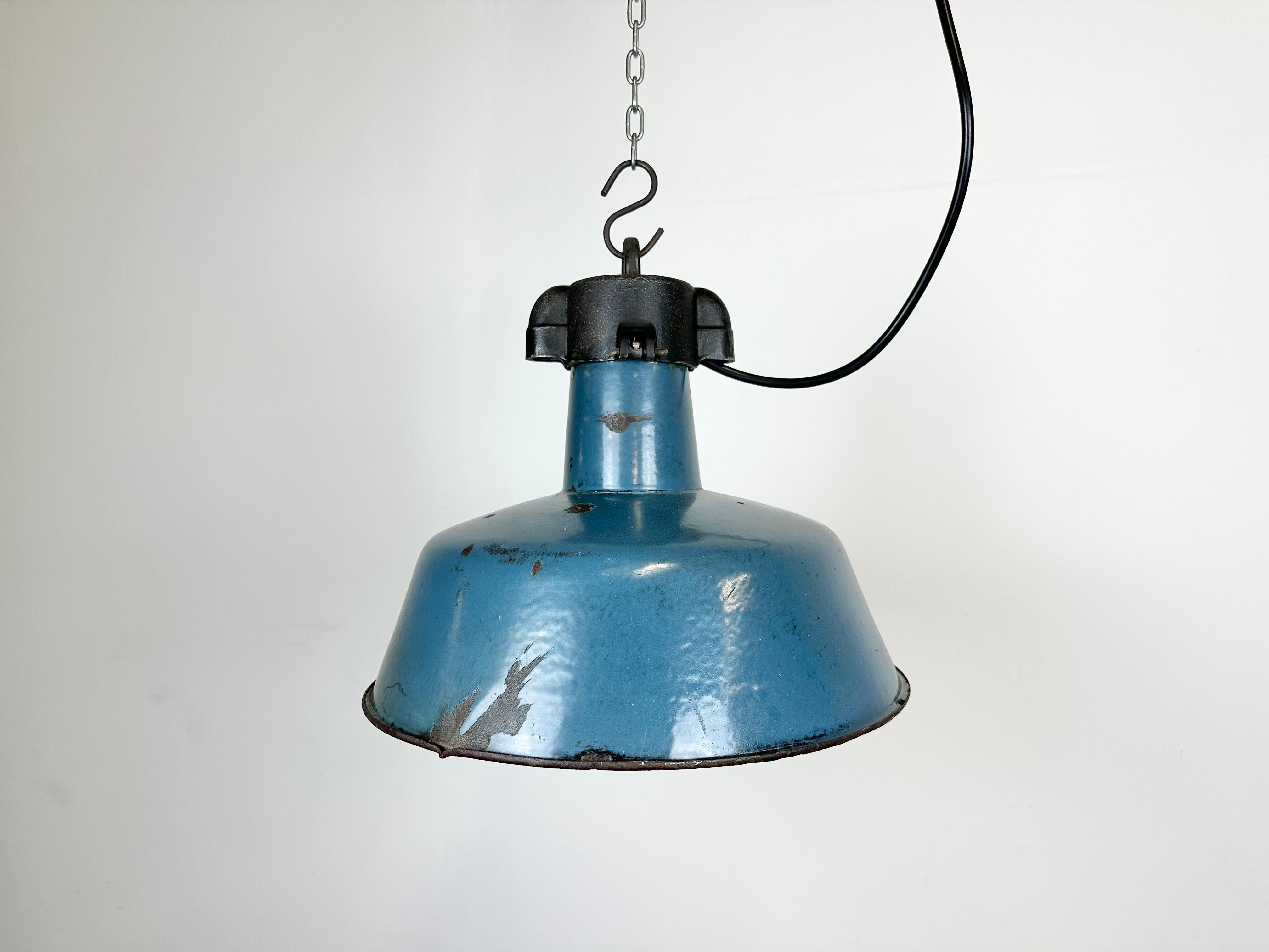 Lampe pendante industrielle en émail bleu fabriquée par Polam Wilkasy en Pologne dans les années 1960. Émail blanc à l'intérieur de la teinte. Dessus en fonte. La douille en porcelaine nécessite des ampoules E 27/ E 26. Un nouveau fil. Le poids de