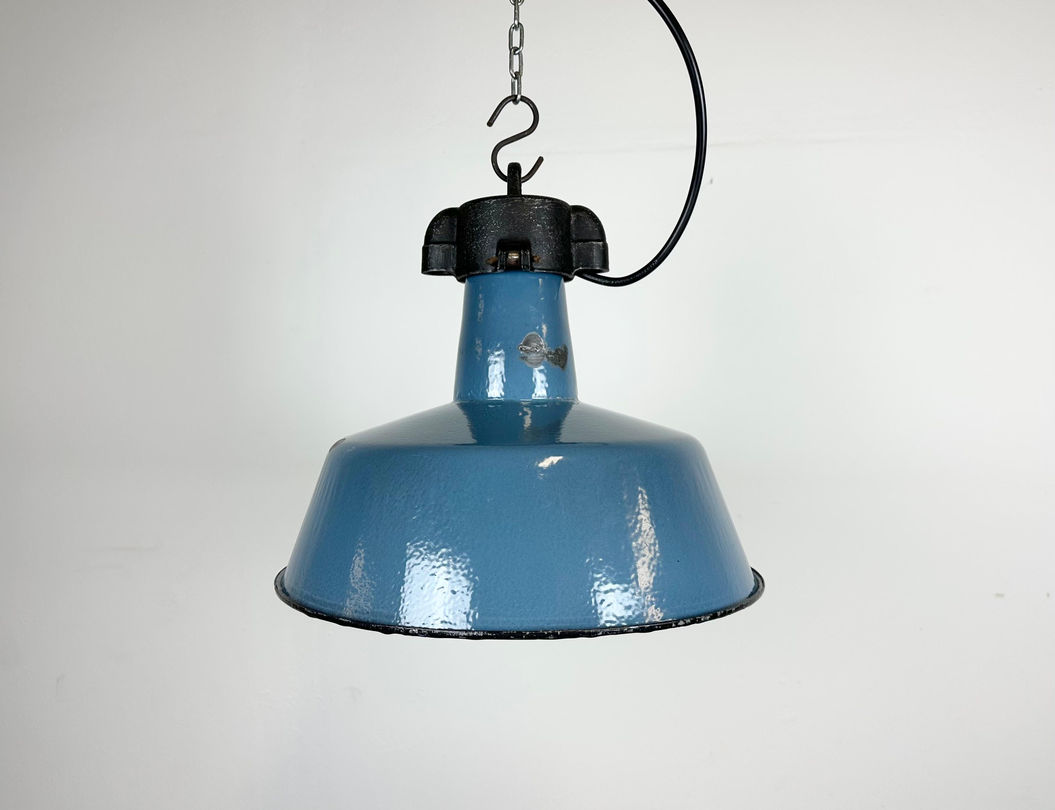 Industrial blue enamel pendant light made by Polam Wilkasy in Poland during the 1960s. White enamel inside the shade. Cast iron top. The porcelain socket requires E 27/ E 26 light bulbs. New wire. The weight of the lamp is 2 kg.