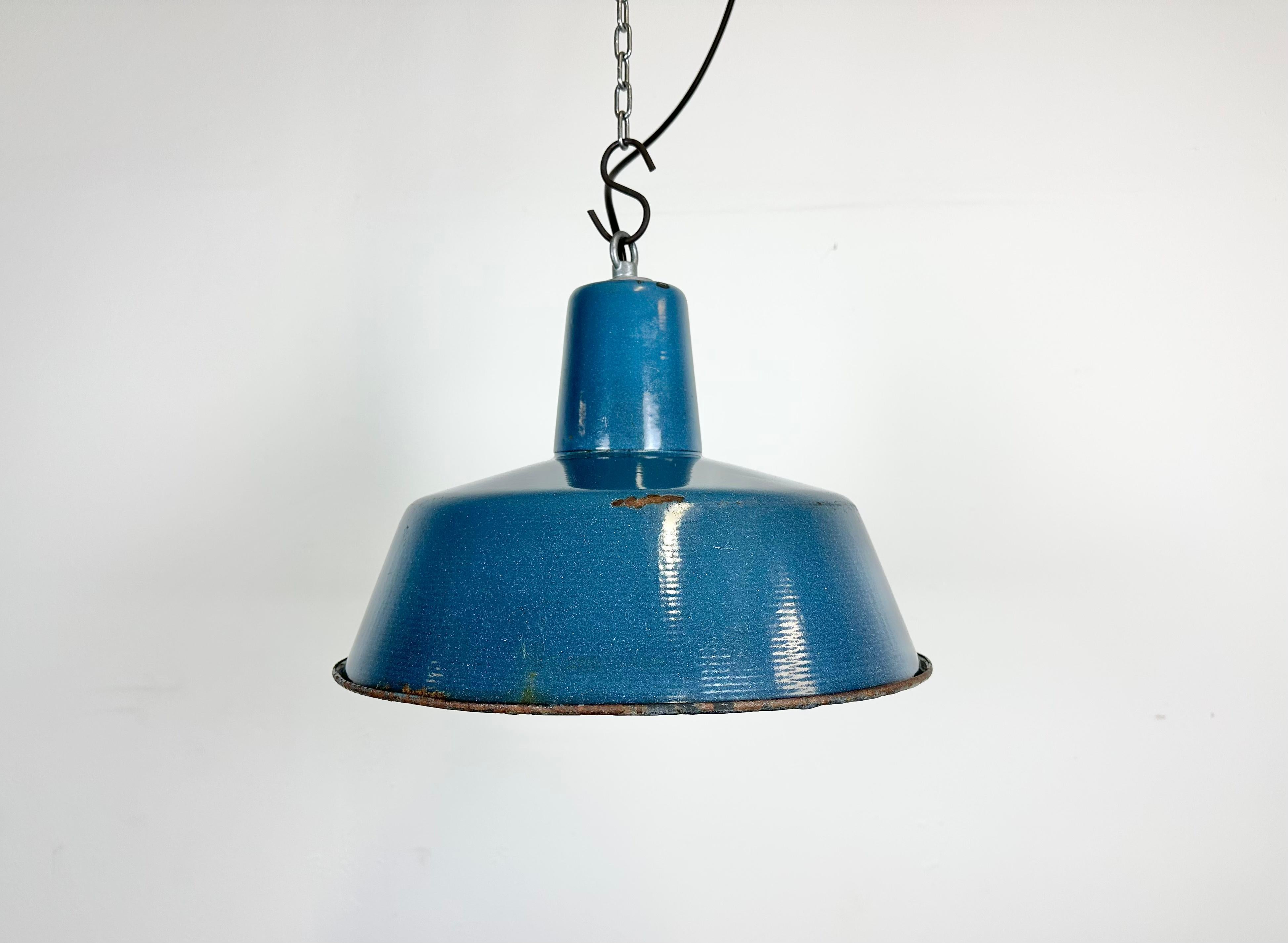 Industrial blue enamel pendant light made in Poland during the 1960s. White enamel inside the shade. Iron top. The porcelain socket requires E 27/ E 26 light bulbs. New wire. Fully functional. The weight of the lamp is 1,2 kg.