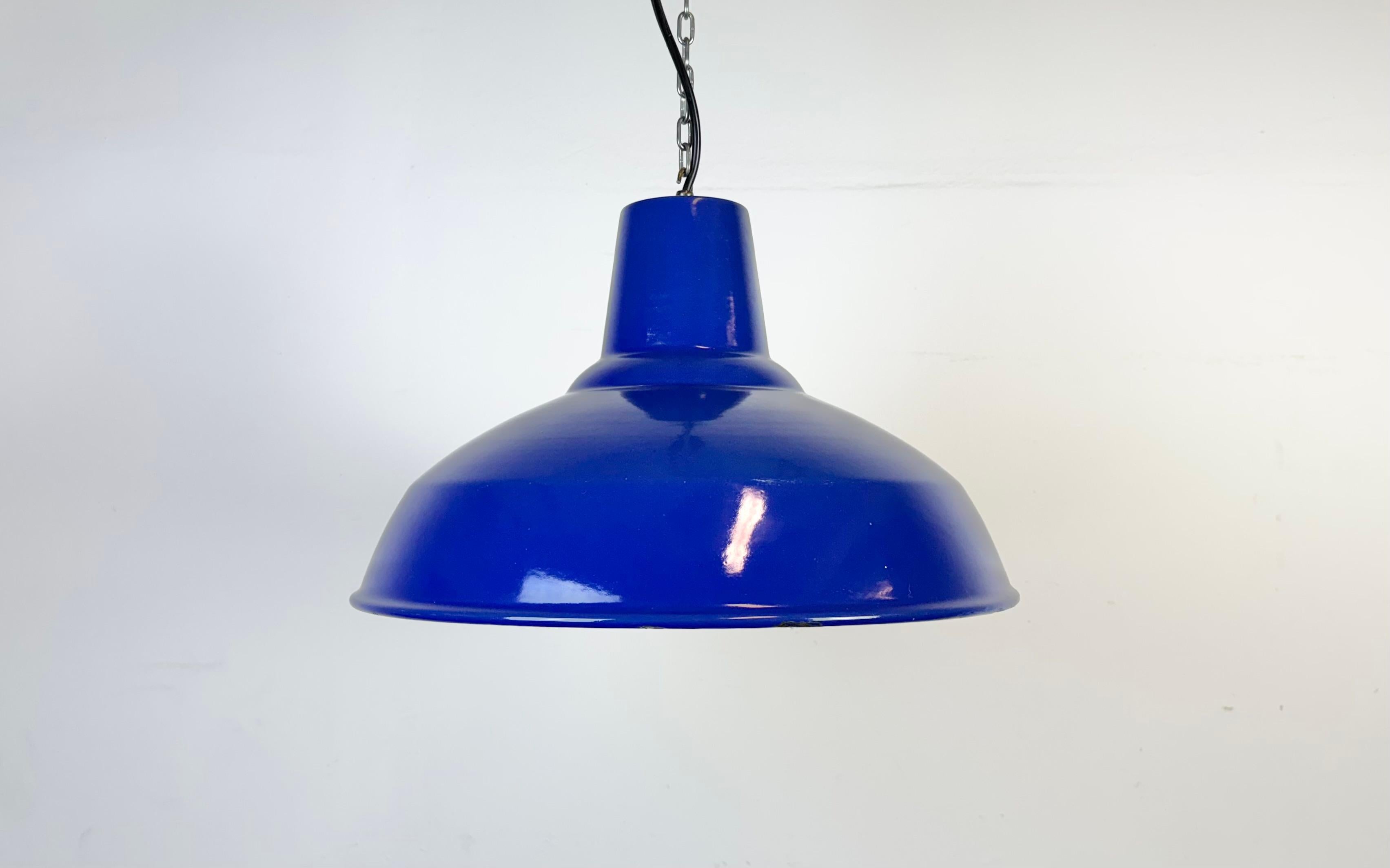 Lampada a sospensione industriale in smalto blu realizzata nel Regno Unito negli anni '60. Smalto bianco all'interno del paralume. Top in ottone. L'attacco richiede lampadine standard E26/E27. Un nuovo cavo. Il peso della lampada è di 1,5 kg. Il
