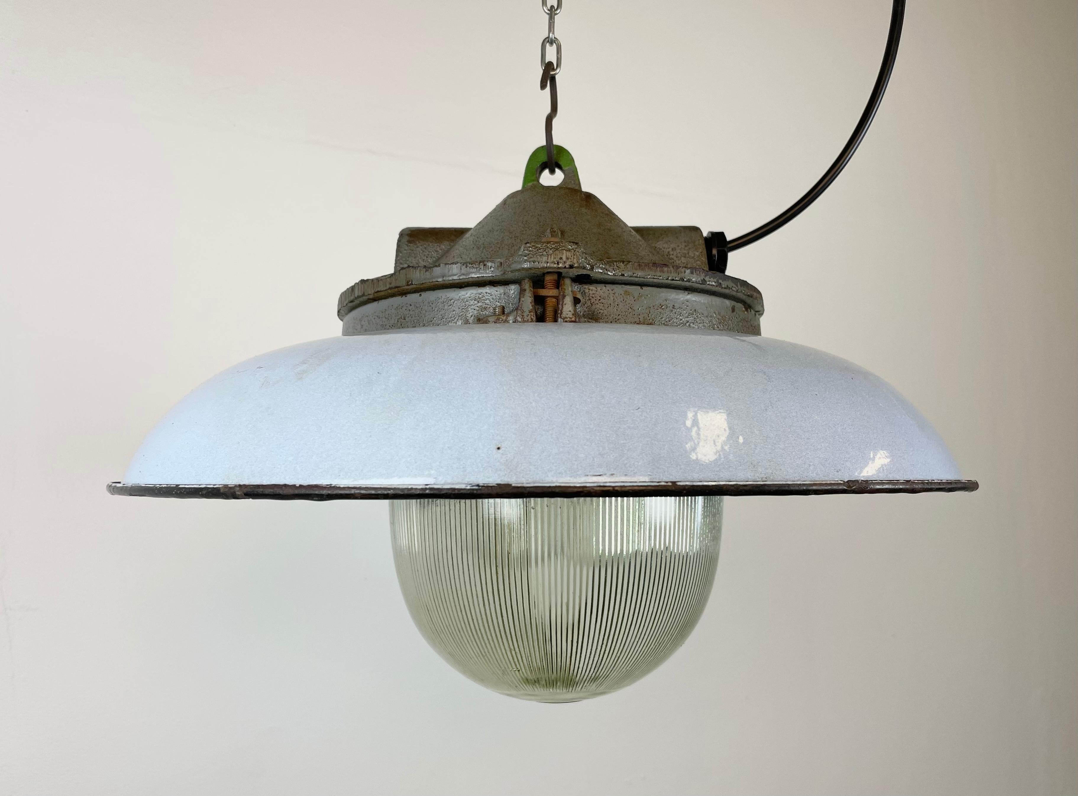 - Lampe pendante industrielle d'usine en fonte
- Fabriqué par Zaos en Pologne dans les années 1960
- Teinte émaillée bleue (grise) avec intérieur émaillé blanc 
- Couverture en verre holophane
- Poids : 7 kg.