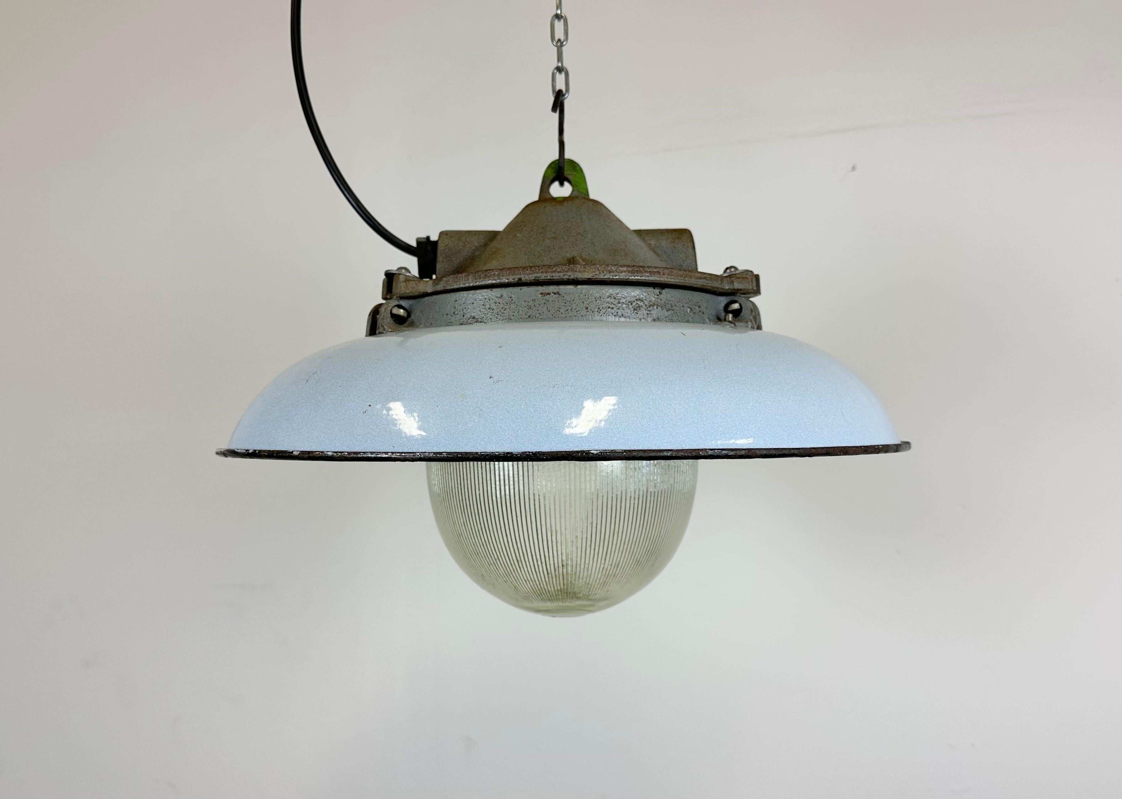- Industrial factory pendant lamp in cast iron
- Manufactured by Zaos in Poland during the 1960s
- Light blue enamel shade with white enamel interior 
- Holophane glass cover
- Weight: 6,8 kg.