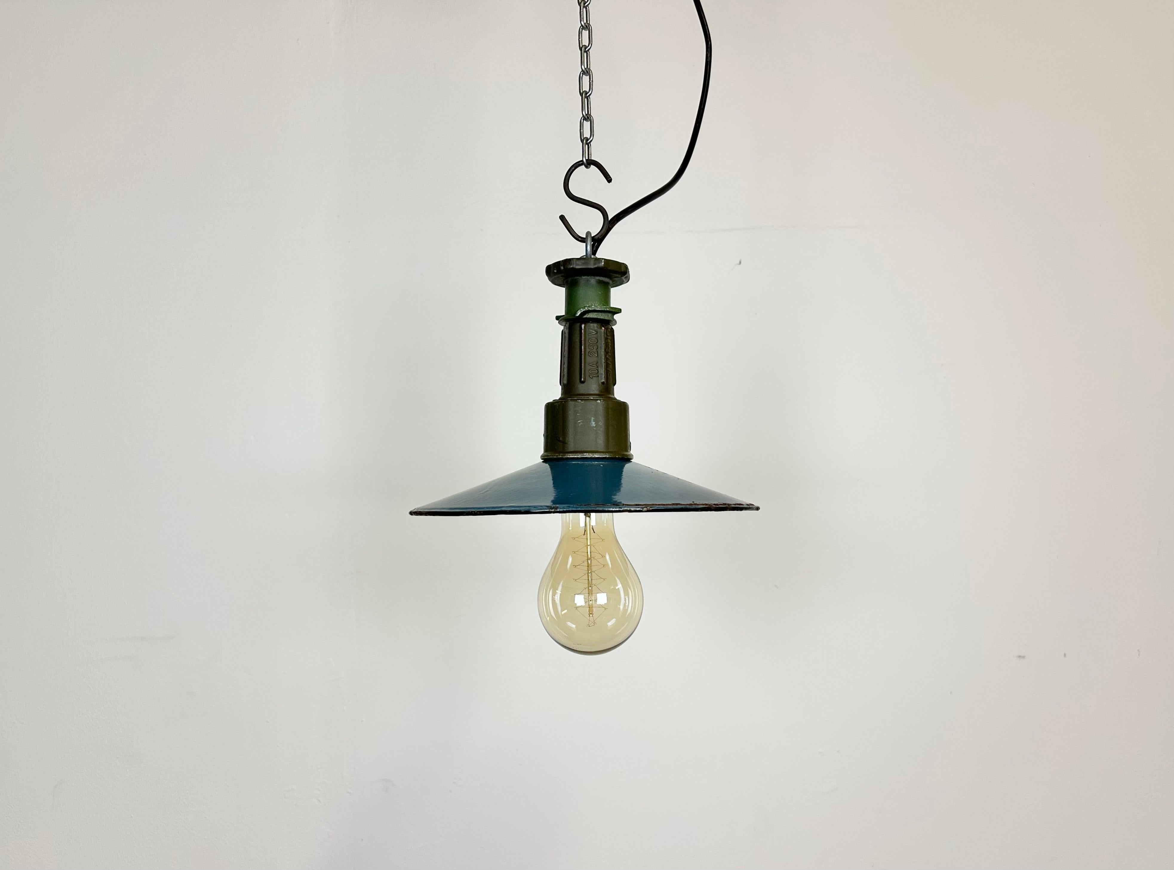 Industrial blue enamel pendant light made in Poland during the 1960s. White enamel inside the shade. Green cast aluminium top. The socket requires E 27/ E26 light bulbs. New wire. The weight of the lamp is 0,5 kg.
The light bulb is not included.