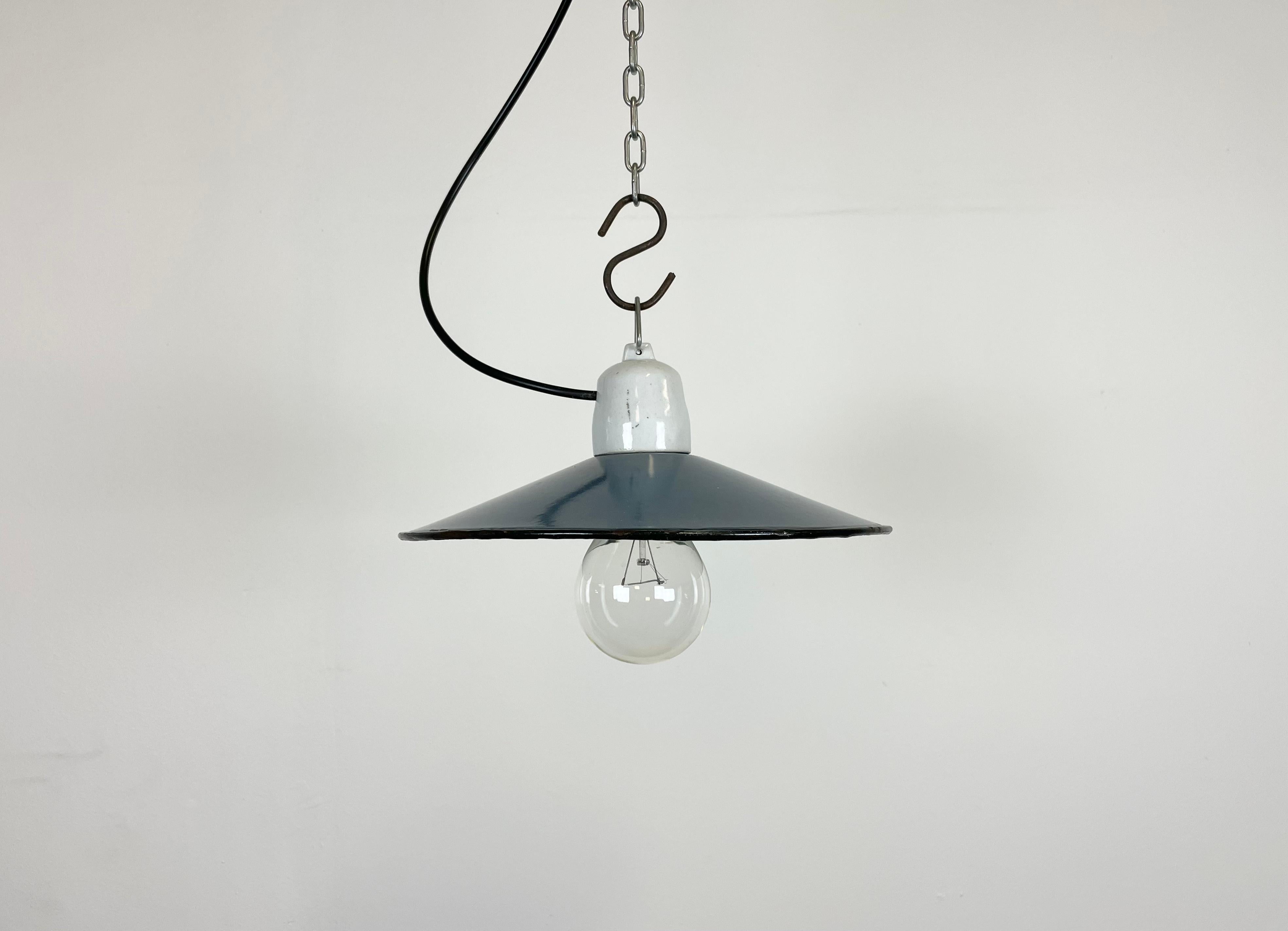 Vintage industrial enamel pendant lamp made in Poland during the 1970s. It features a blue enamel shade with white enamel interior and porcelain top. The socket requires E 27 light bulbs. The weight of the lamp is 0,5 kg. New wire.