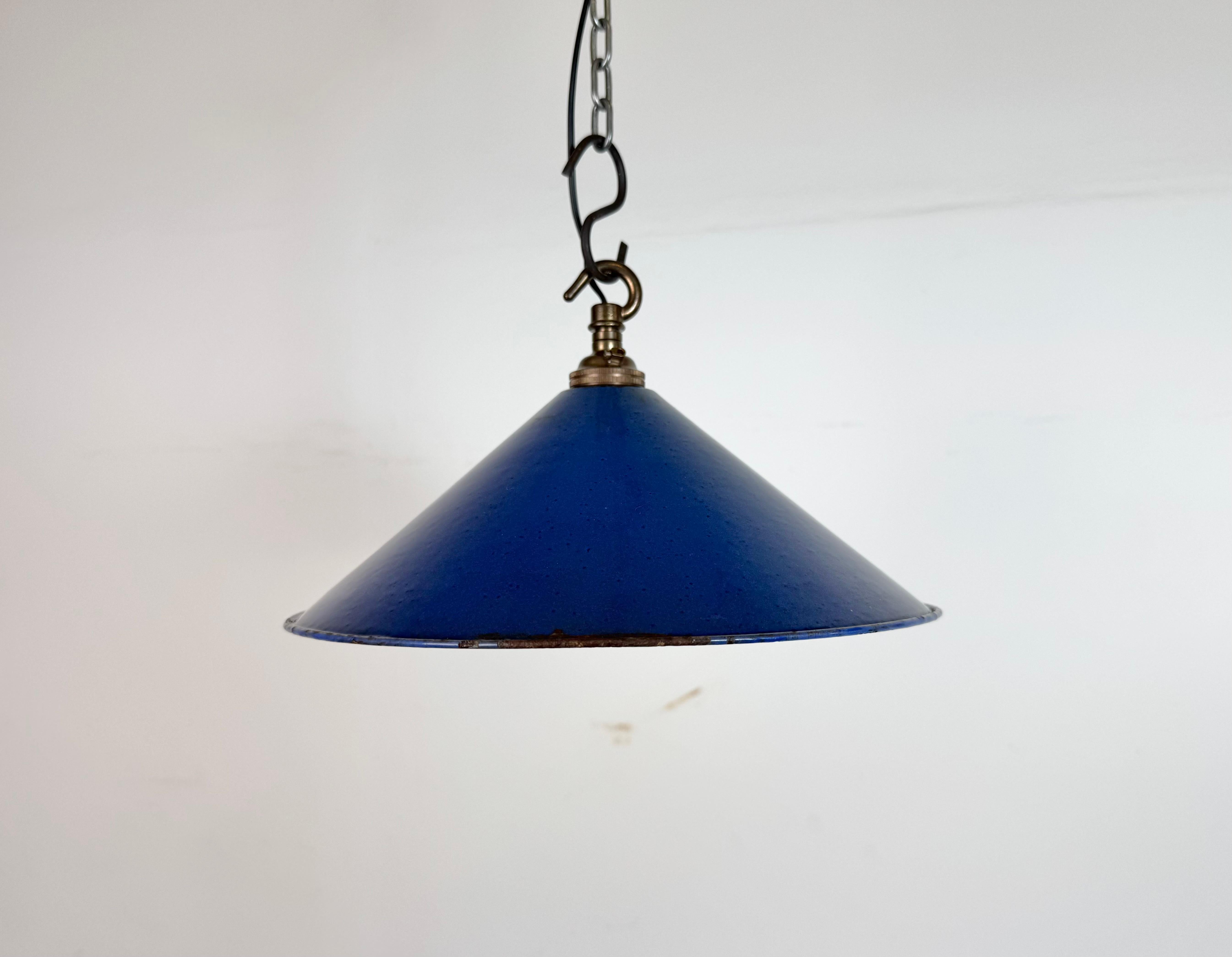 Industrial blue enamel factory pendant light made in United Kingdom during the 1950s. White enamel inside the shade. Brass top. The socket requires bayonet B22 light bulbs. New wire. The weight of the lamp is 0,3 kg.The diameter of the shade is 25