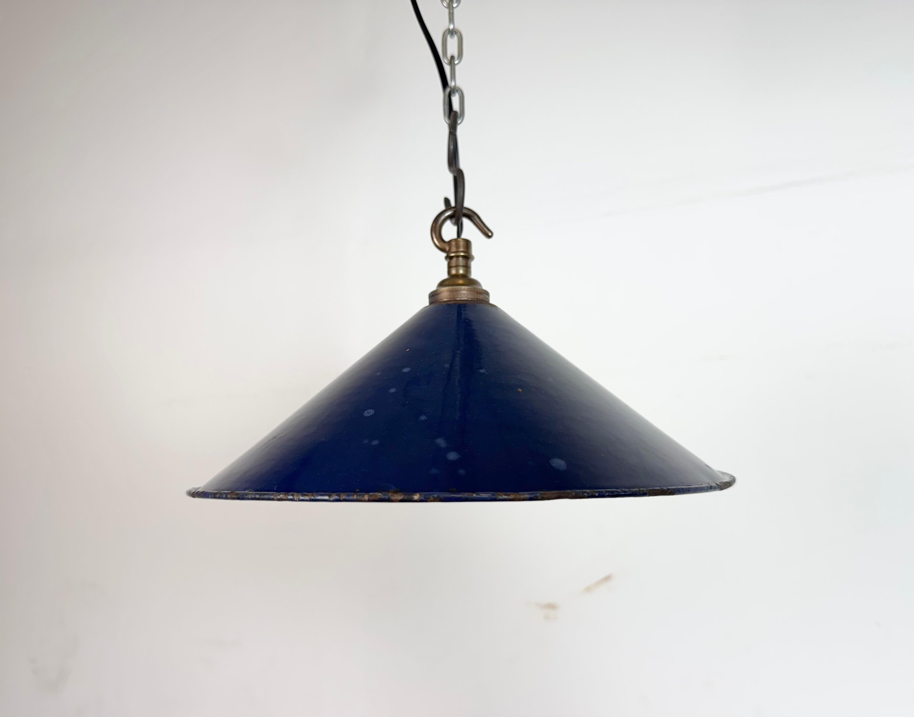 Industrial dark blue enamel factory pendant light made in United Kingdom during the 1950s. White enamel inside the shade. Brass top. The socket requires bayonet B22 light bulbs. New wire. The weight of the lamp is 0,3 kg.The diameter of the shade is
