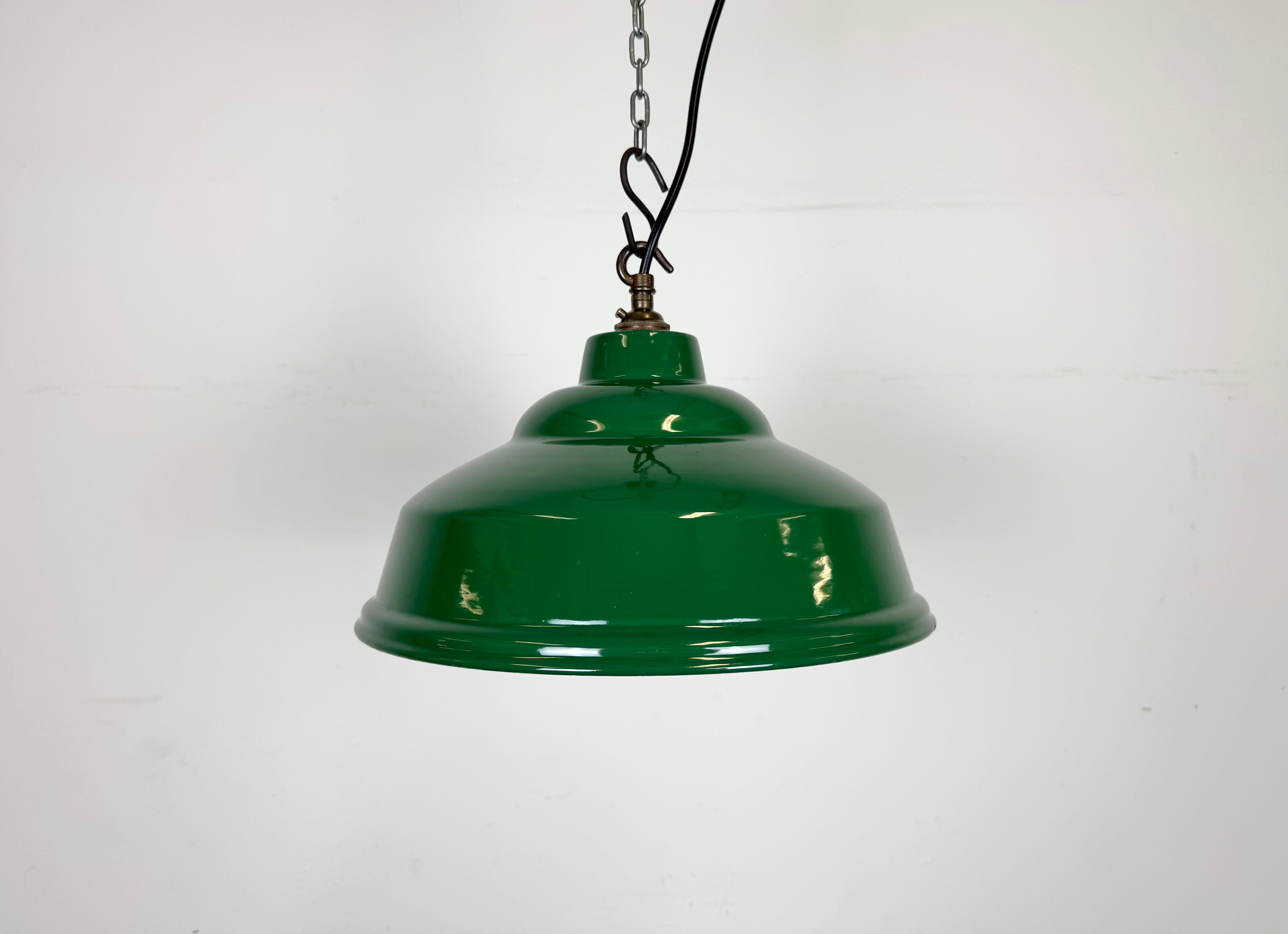 Lampada a sospensione industriale in smalto verde realizzata nel Regno Unito negli anni Sessanta. Smalto bianco all'interno del paralume. Top in ottone. L'attacco richiede lampadine a baionetta B22. Un nuovo cavo. Il peso della lampada è di 0,8 kg.