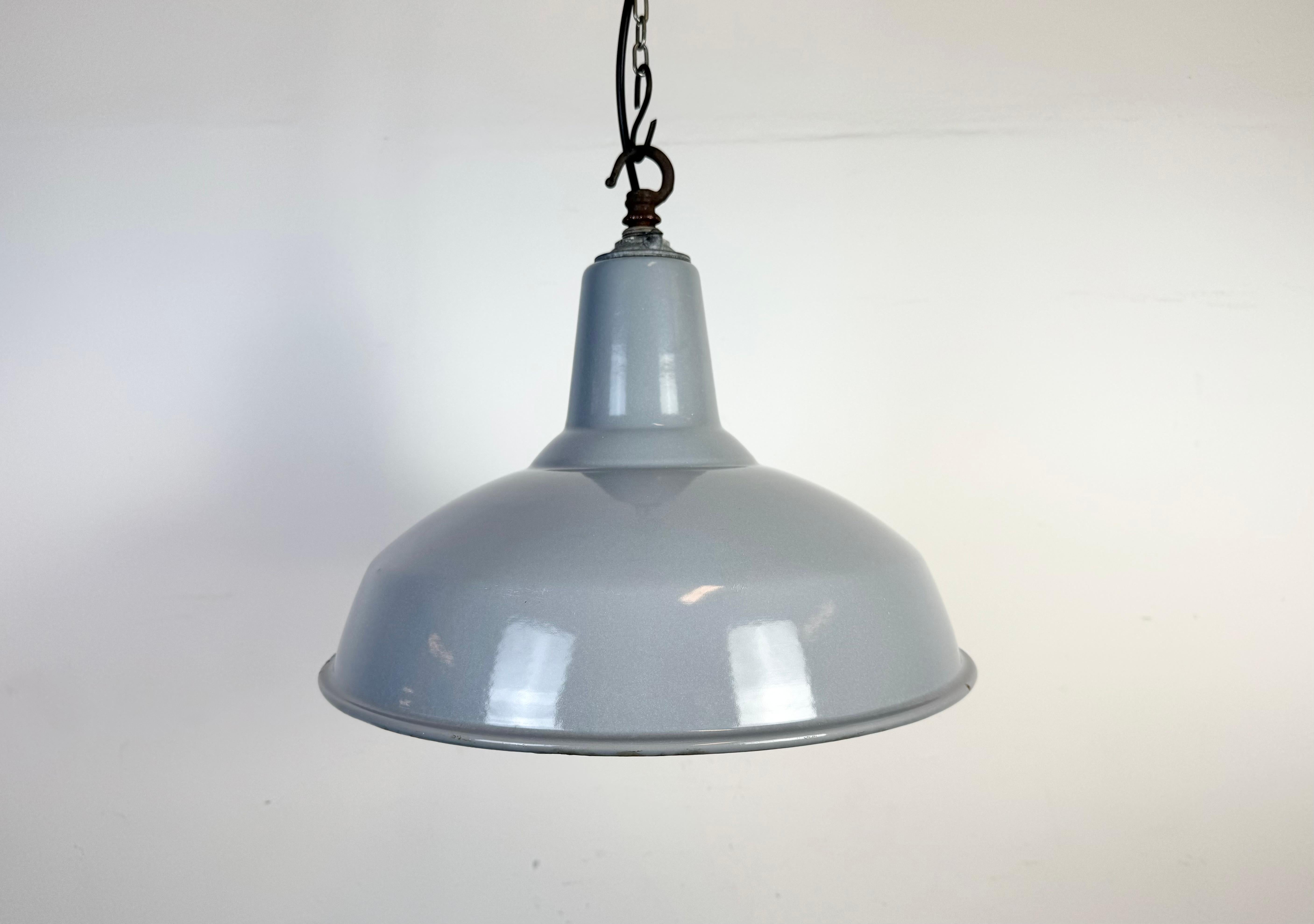 Suspension industrielle en émail gris fabriquée au Royaume-Uni dans les années 1960. Émail blanc à l'intérieur de la teinte. Dessus en fer. La douille est compatible avec les ampoules standard E27/ E26. Un nouveau fil. Le poids de la lampe est de 2