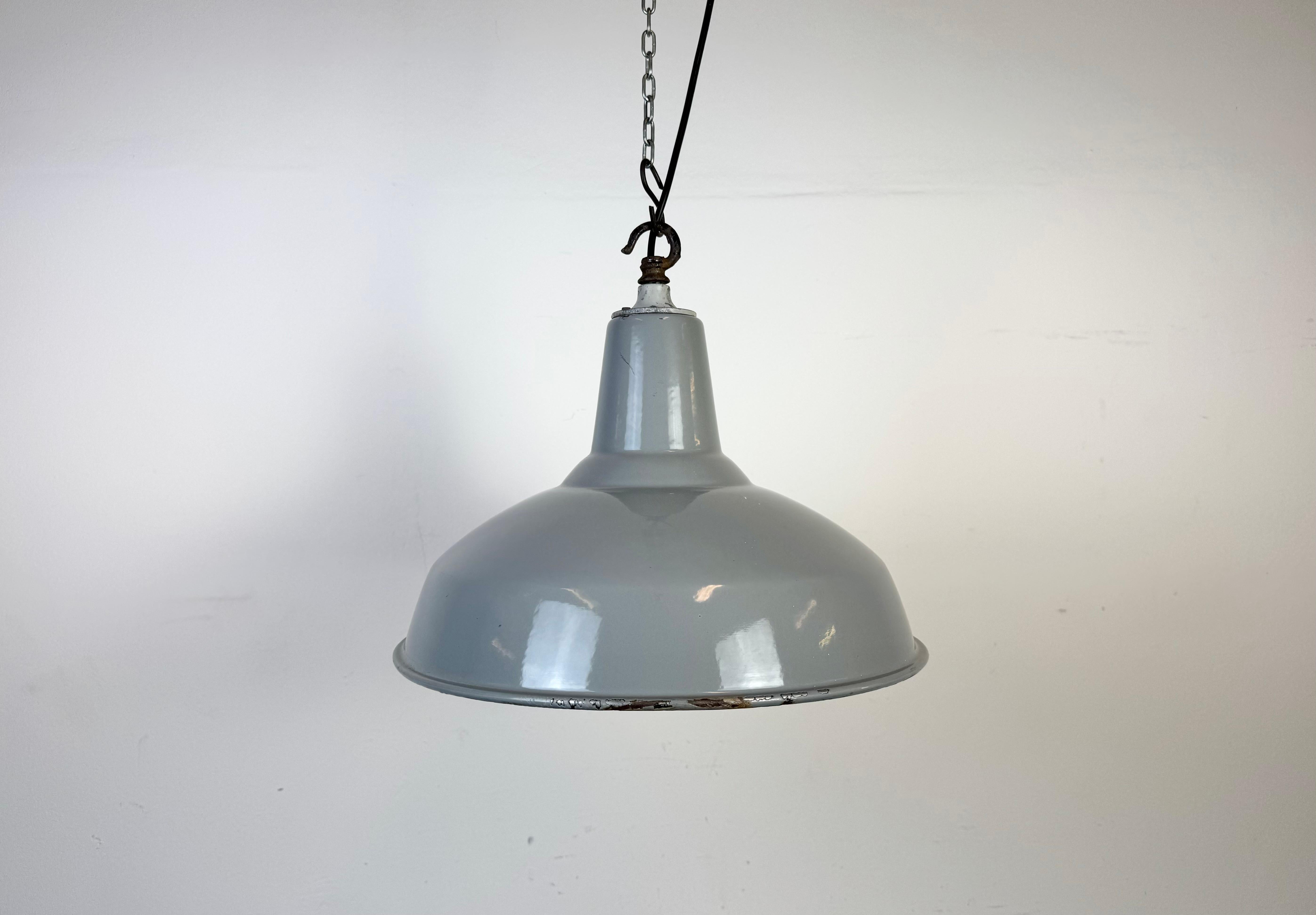 Industrial grey enamel factory pendant light made in United Kingdom during the 1960s. White enamel inside the shade. Iron top. The socket requires standard E27/ E26 light bulbs. New wire. The weight of the lamp is 1,9 kg.The diameter of the shade is