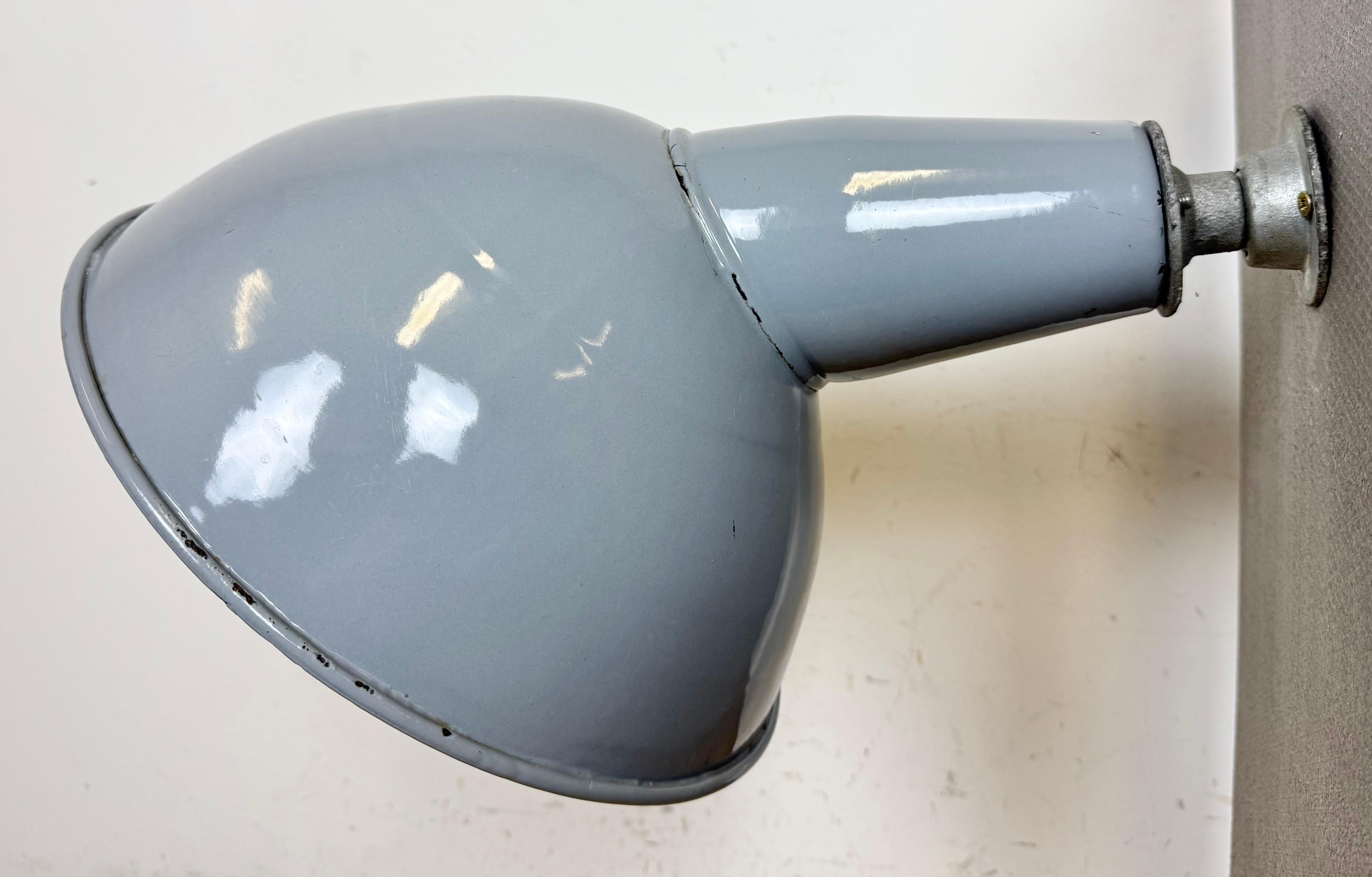 Aplique industrial de fábrica de esmalte gris fabricado en el Reino Unido en la década de 1960. Esmalte blanco en el interior de la pantalla. Fijación mural de hierro. El casquillo requiere bombillas estándar E27/ E26. Cable nuevo. El peso de la