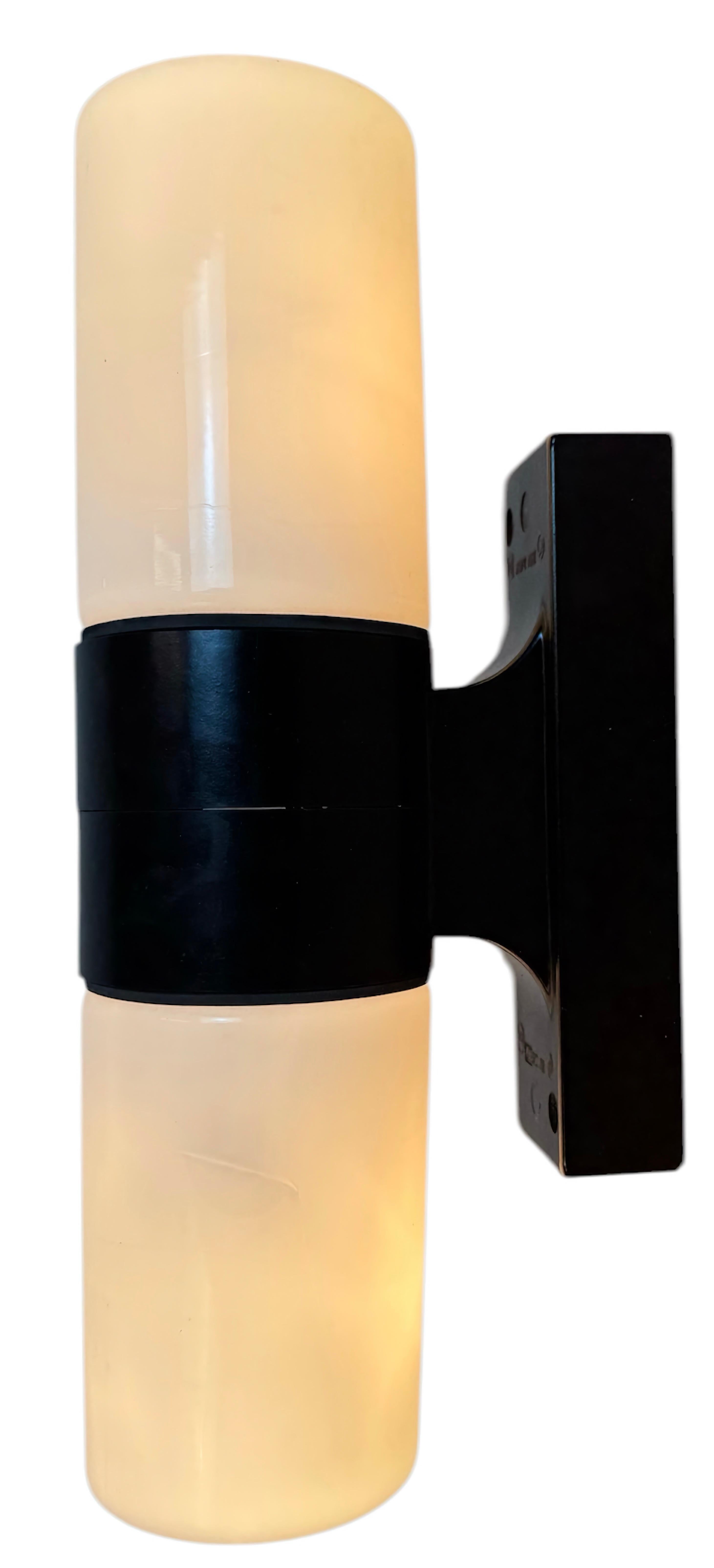 Vintage industrial dark brown bakelite wall lamp made in former Czechoslovakia during the 1960s. It features a bakelite wall mounting and two milk glass covers. The sockets require two E 14 light bulbs.  The weight of the light : 0,9 kg.The diameter