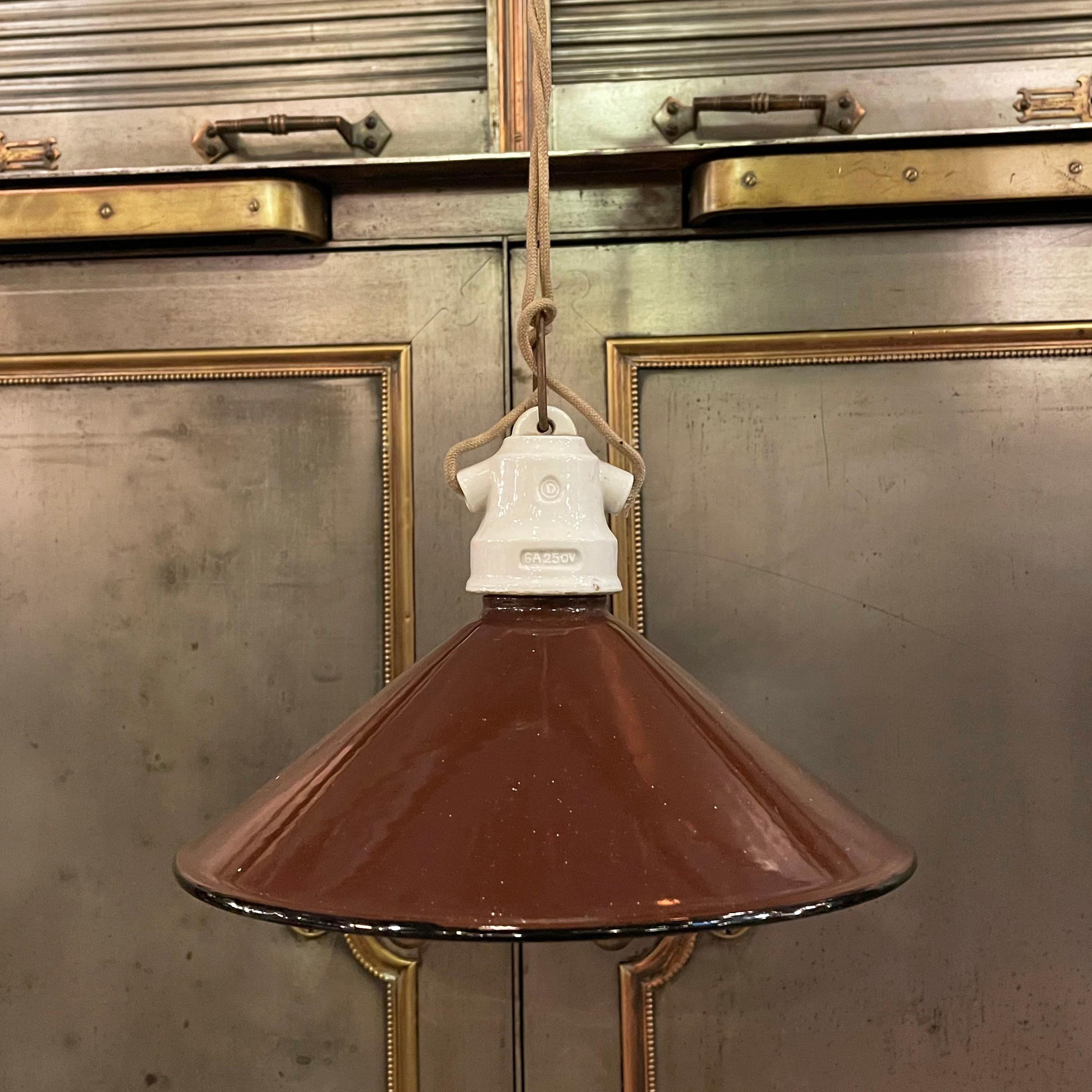 Early 20th century, industrial, factory pendant light with brown enameled, cone shape, metal shade and porcelain fitter is newly wired with 48 inches of beige braided cloth cord. 