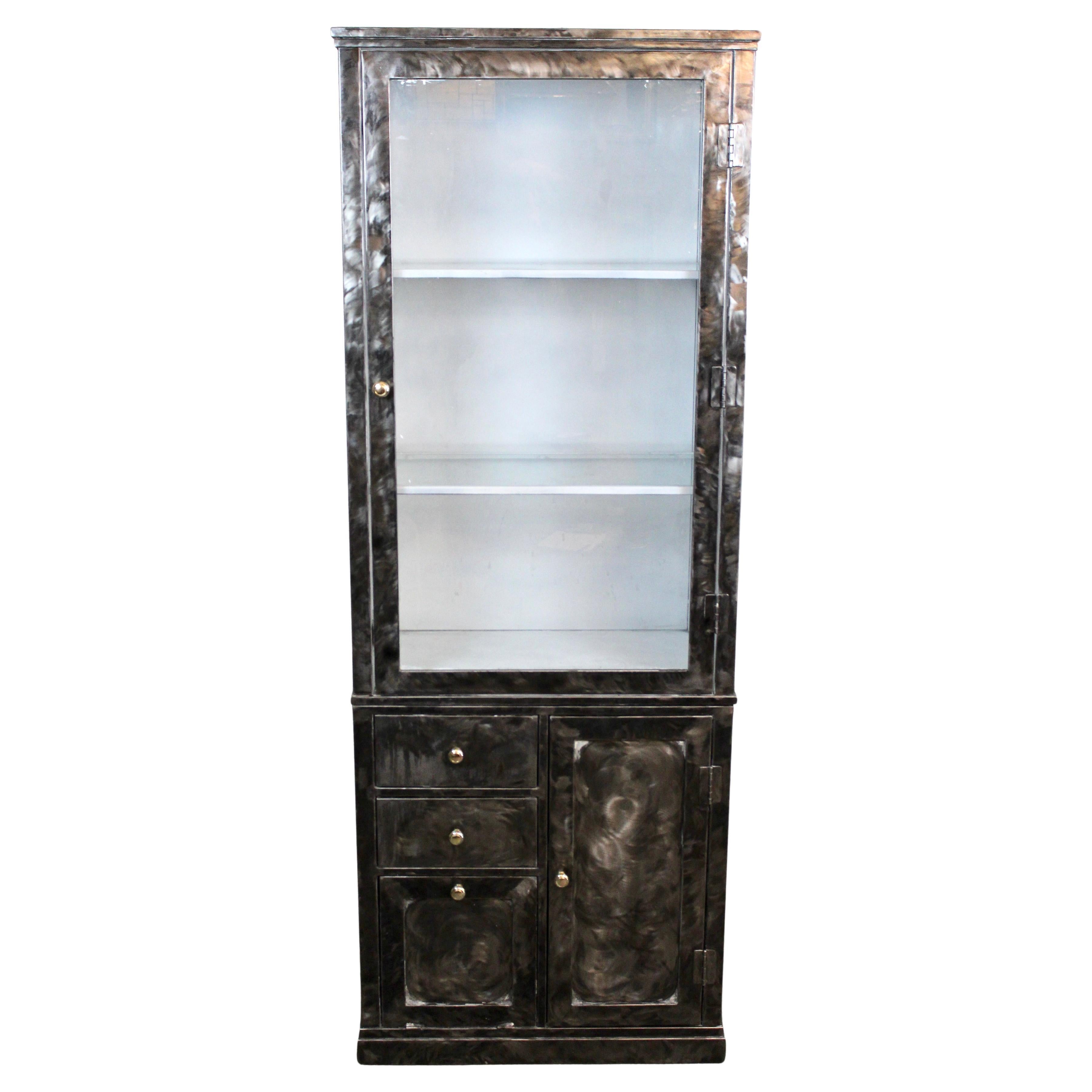 Add a splash of gritty presence into any space with this robust industrial metal cabinet looking straight out of the machine age! Standing over 6 feet tall, this steel structure features a large windowed display cabinet with two inlaid glass shelves