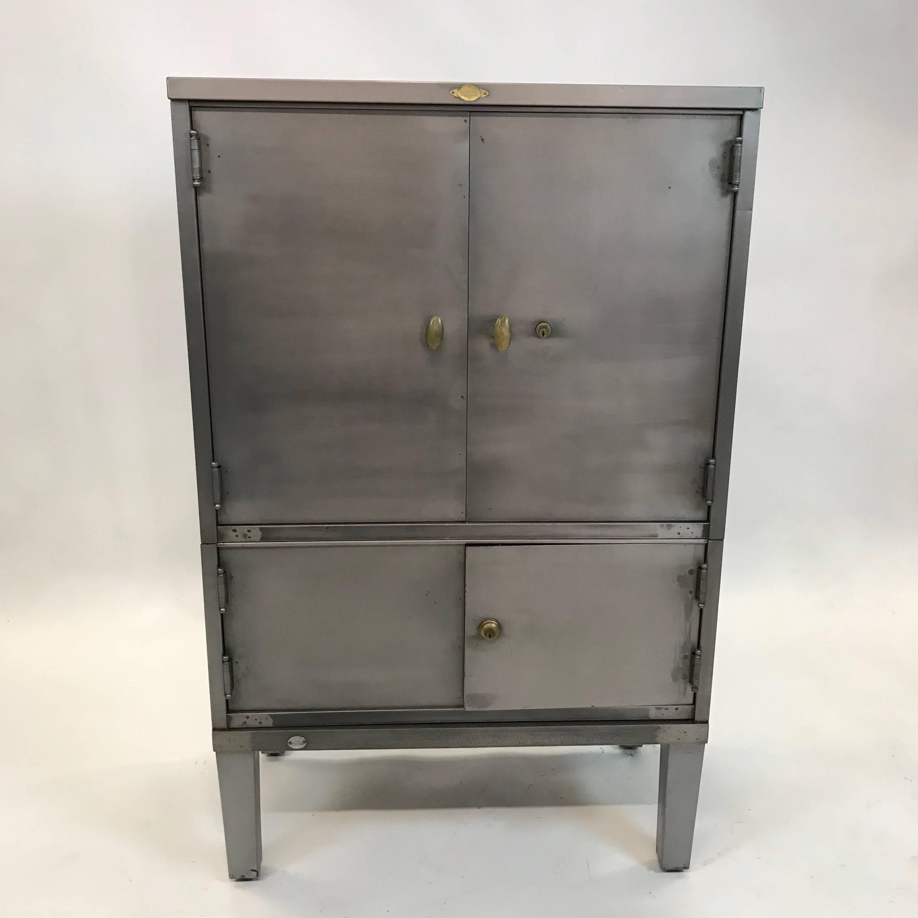 1930s industrial, Art Deco, office, document cabinet by Art Metal features a newly brushed steel finish with brass accents has closed top storage 25 inches height and bottom storage at 13 inches height. Interior finish is its original brown finish.