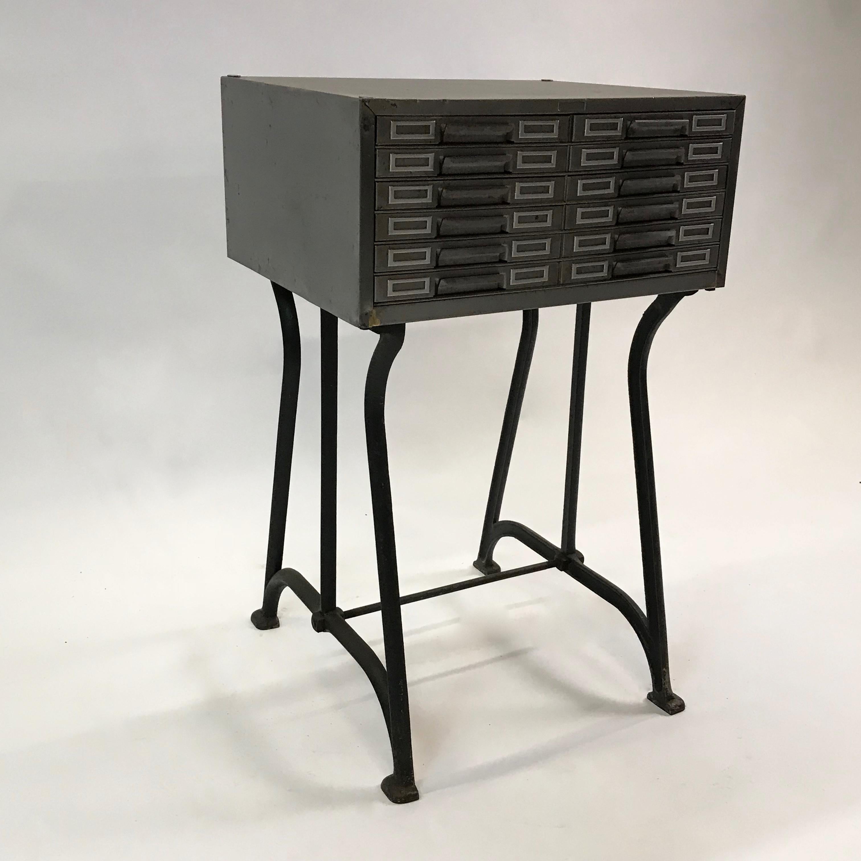 Industrial, brushed steel, catalog cabinet on a cast iron base holds multiple index cards, photos or postcards for flat, easy access storage. The cabinet itself measures: 20 W x 18 D x 9 inches height. The chair shown has sold.