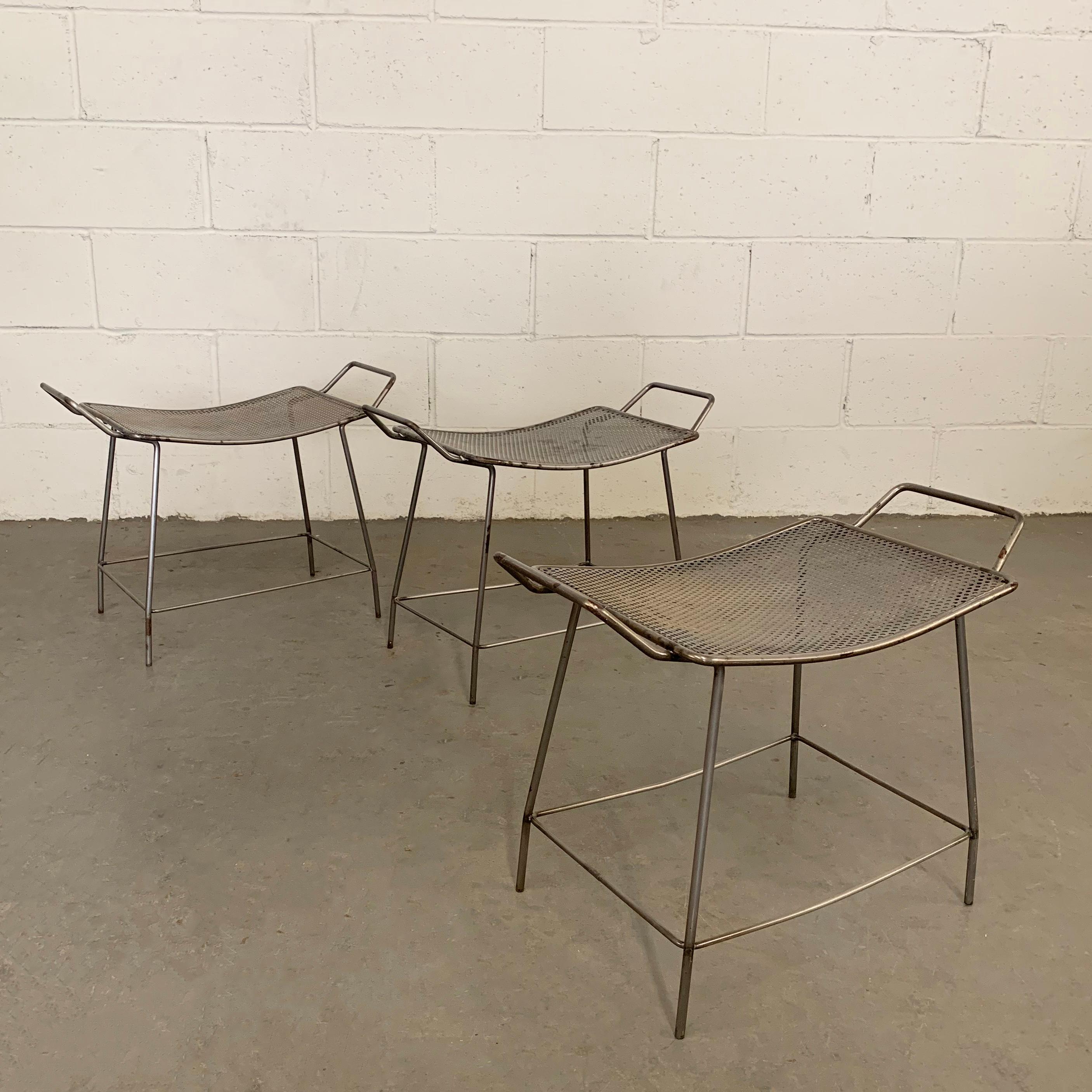 Industrial, brushed steel, short, hospital stools feature seats that slope down one inch with handles on either side. The stools are sold separately.