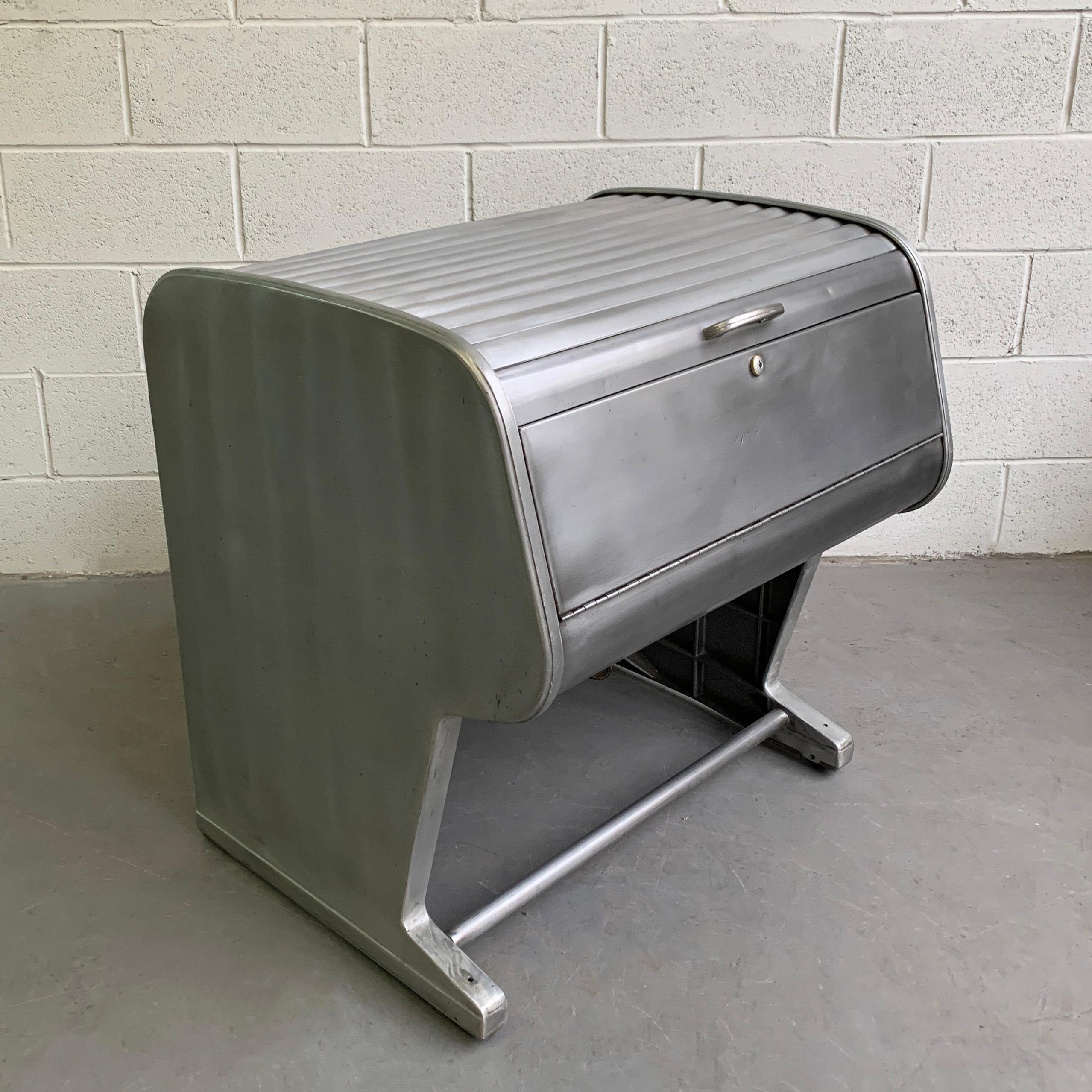 Industrial, midcentury, rolling, medical X-ray file cabinet features a futuristic form with roll-top opening and pull-down front. The interior meant to hold long files measures 27 W x 20 D x 8.25 inches height. The cabinet is finished on all sides.