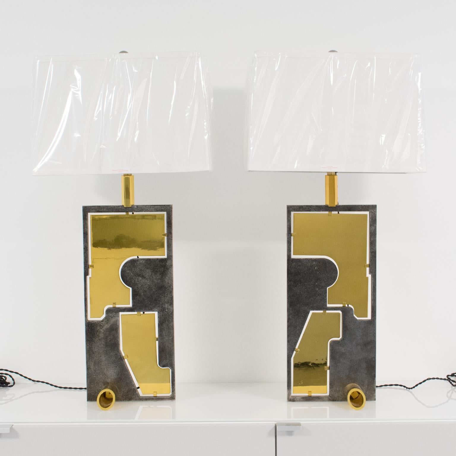 These impressive sculptural modernist industrial table lamps dated from the 1980s. They feature an elongated geometric shape with high gloss polished brass metal elements inserted in solid steel laser-cut molds and a sturdy tubular base in the same