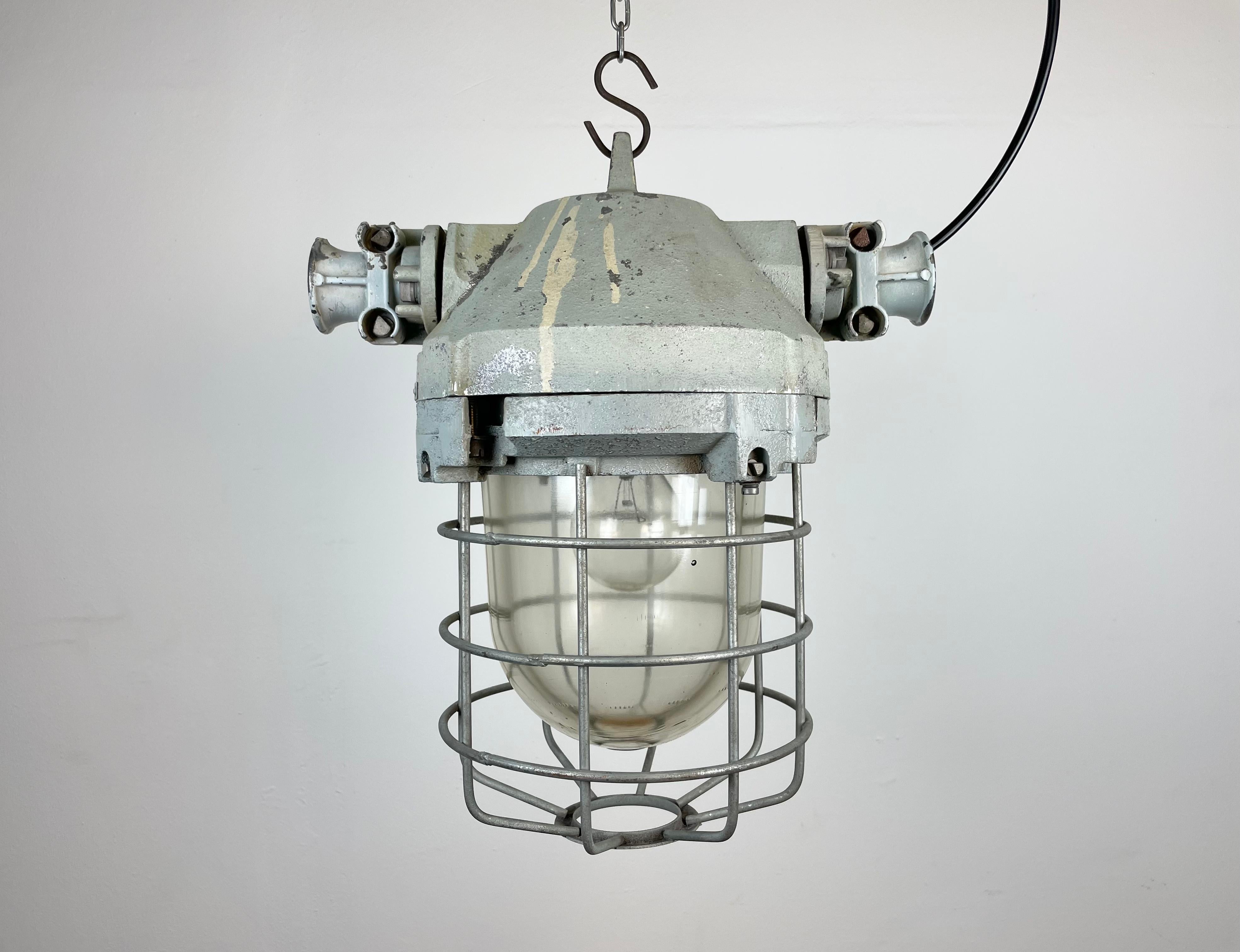 Industrial factory light manufactured by Elektrosvit in former Czechoslovakia during the 1970s. It features a cast aluminium body, an iron cage and explosion-proof glass.
The socket requires E27 lightbulbs. New wire. The weight of the lamp is 9 kg.