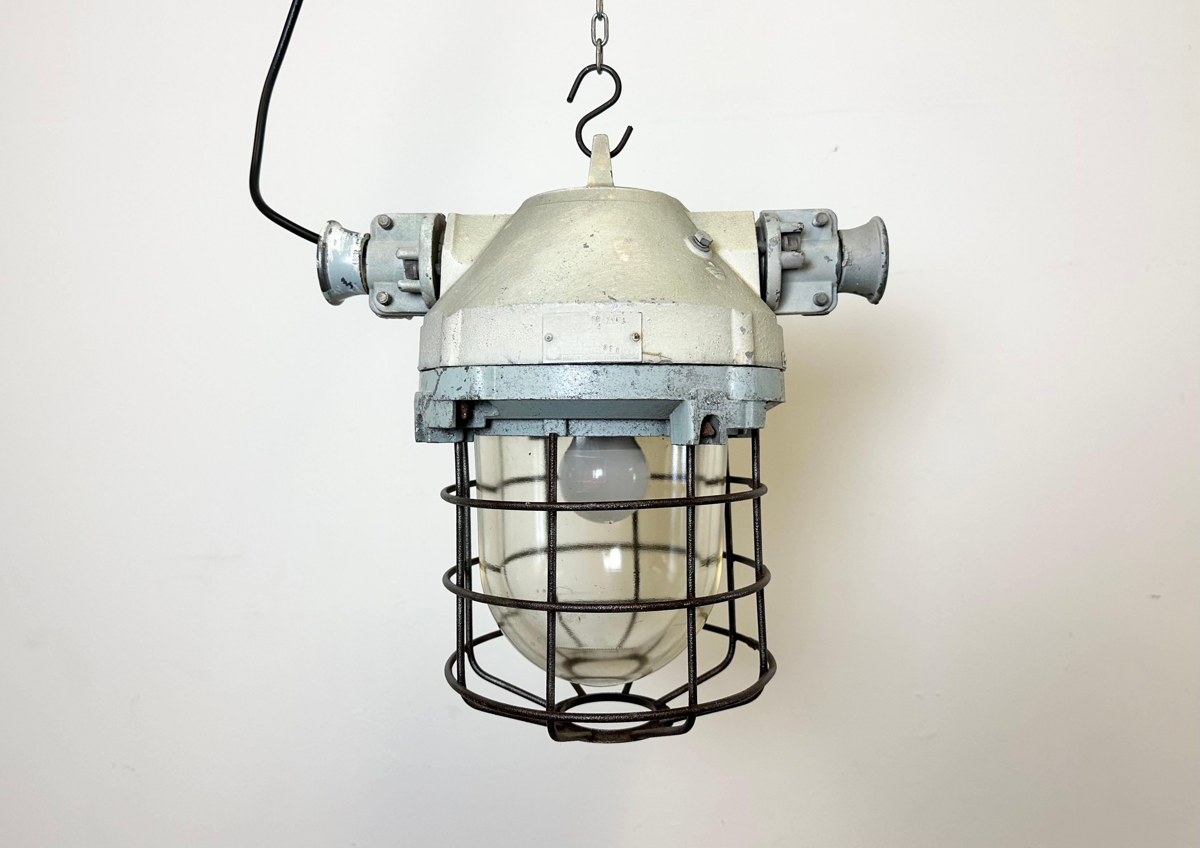 Lampe industrielle d'usine fabriquée par Elektrosvit dans l'ancienne Tchécoslovaquie au cours des années 1970. Il se compose d'un corps en fonte d'aluminium, d'une cage en fer et d'un verre antidéflagrant.
La douille est compatible avec les ampoules