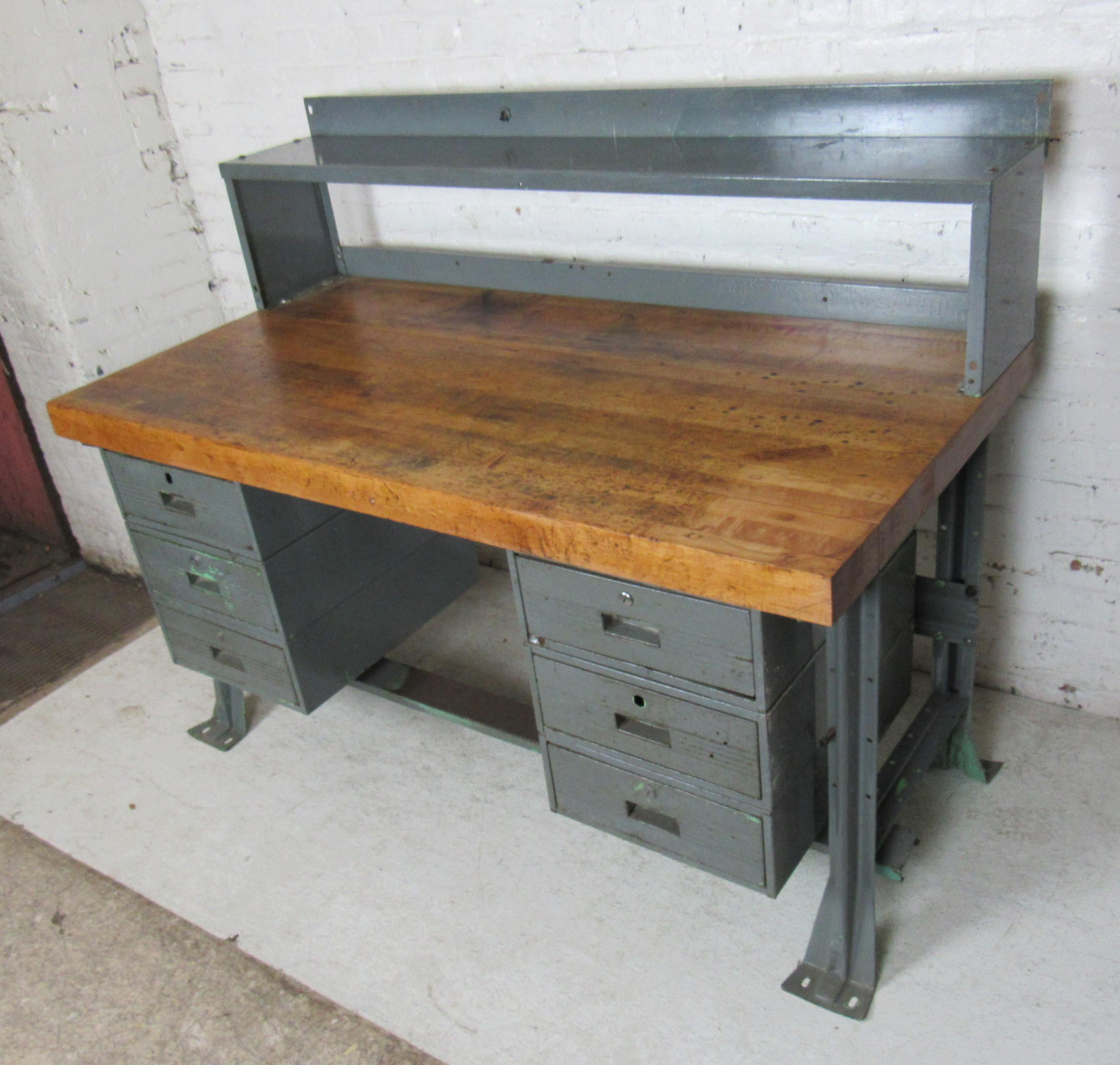 A large industrial-style desk that features a heavy butcher block surface for projects, and several metal drawers. This piece is full of character and built with sturdy quality.

(Please confirm item location - NY or NJ - with dealer).