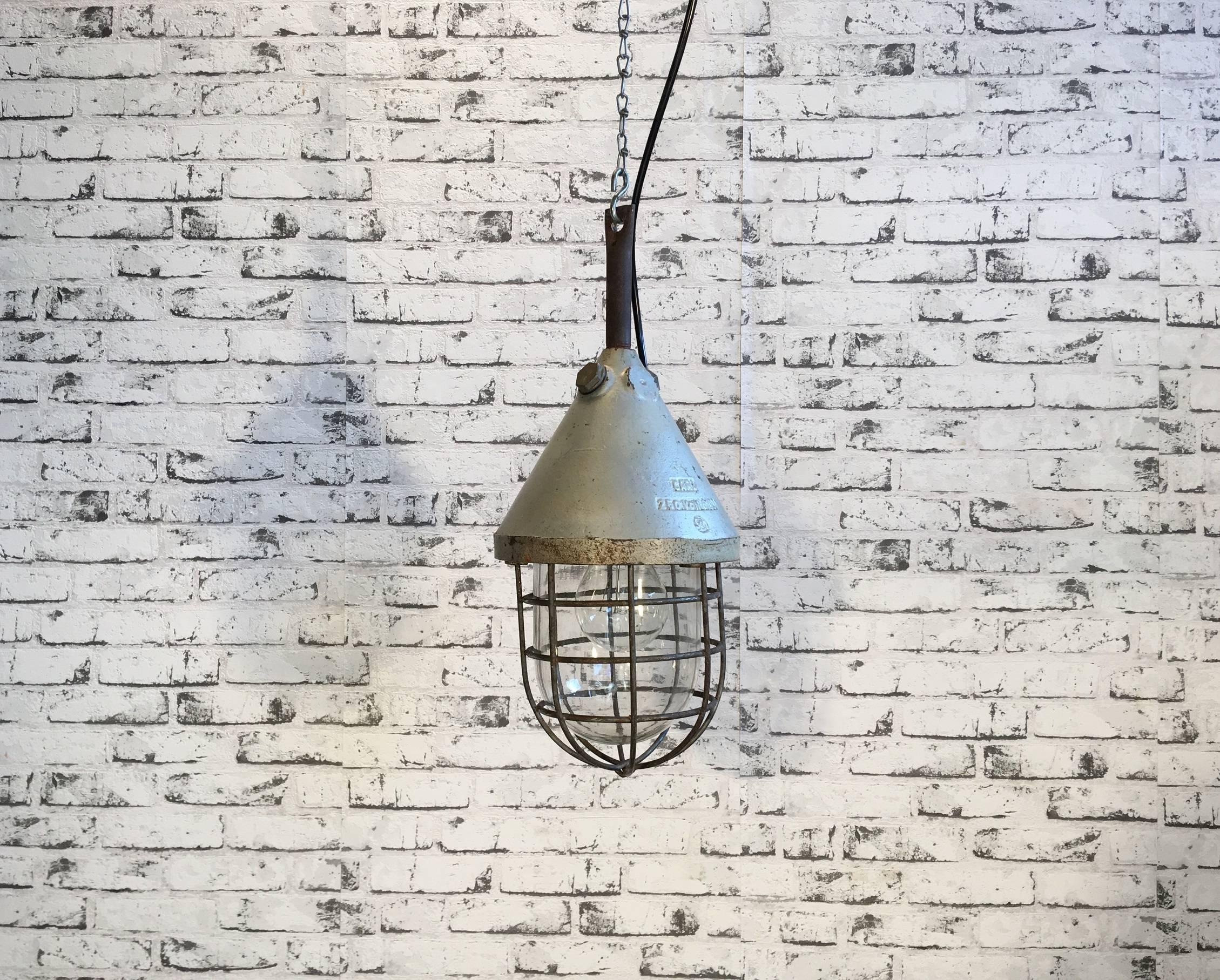 Industrial bunker lamp, 1960s. Caged lamp made of cast iron and explosion-proof glass. Model widely used in chemical factories and mines. Rewired to normal standards and can be used with a regular E27 light bulb.
Weight: 5 kg.