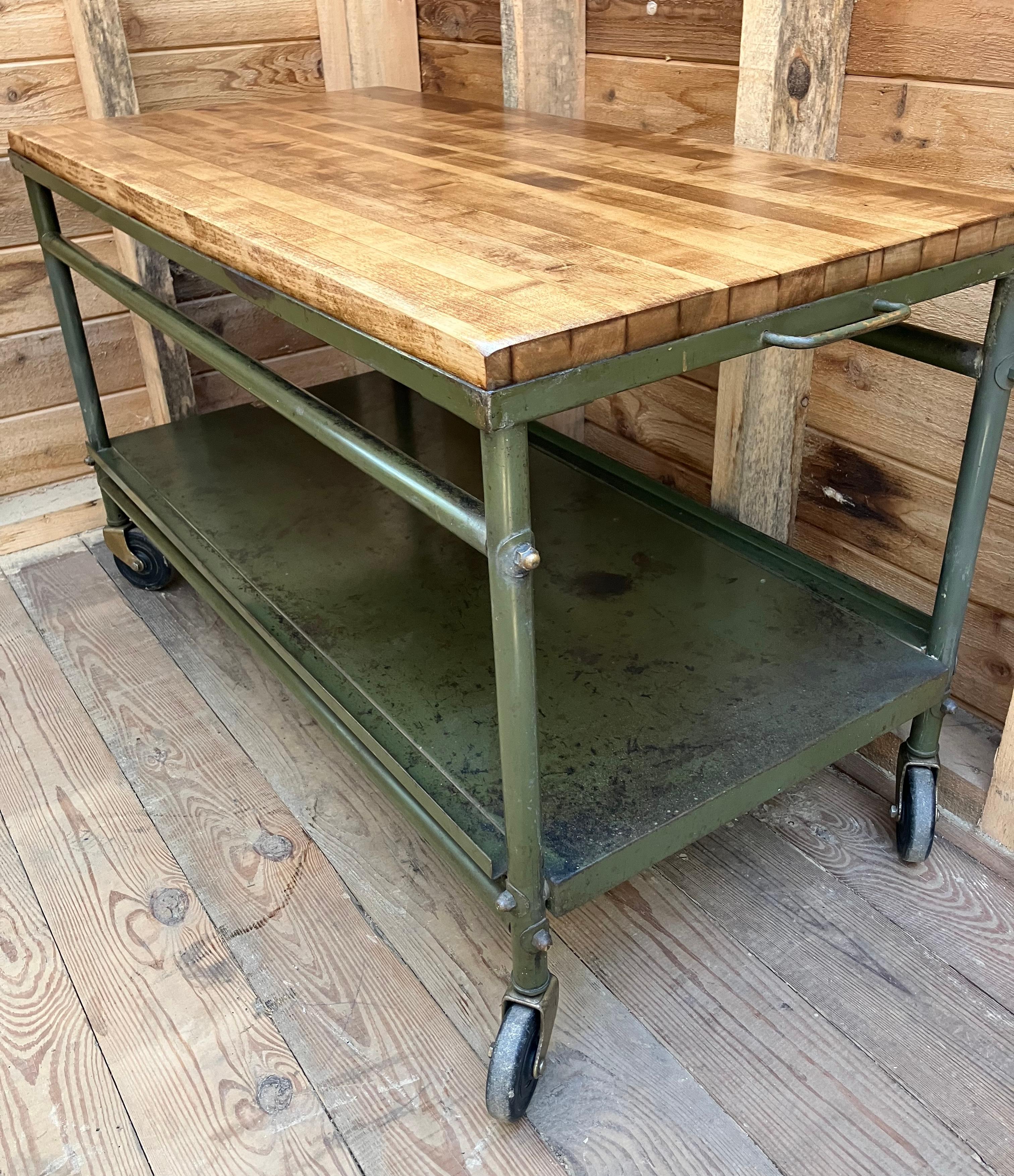 World War 2 era heavy duty steel cart possibly US Army with restored vintage butcher block top. Paint shows wear and some discoloration. Very sturdy and wheels easily. 
Nice cocktail table, tv stand, or mud room bench. Industrial design that lends