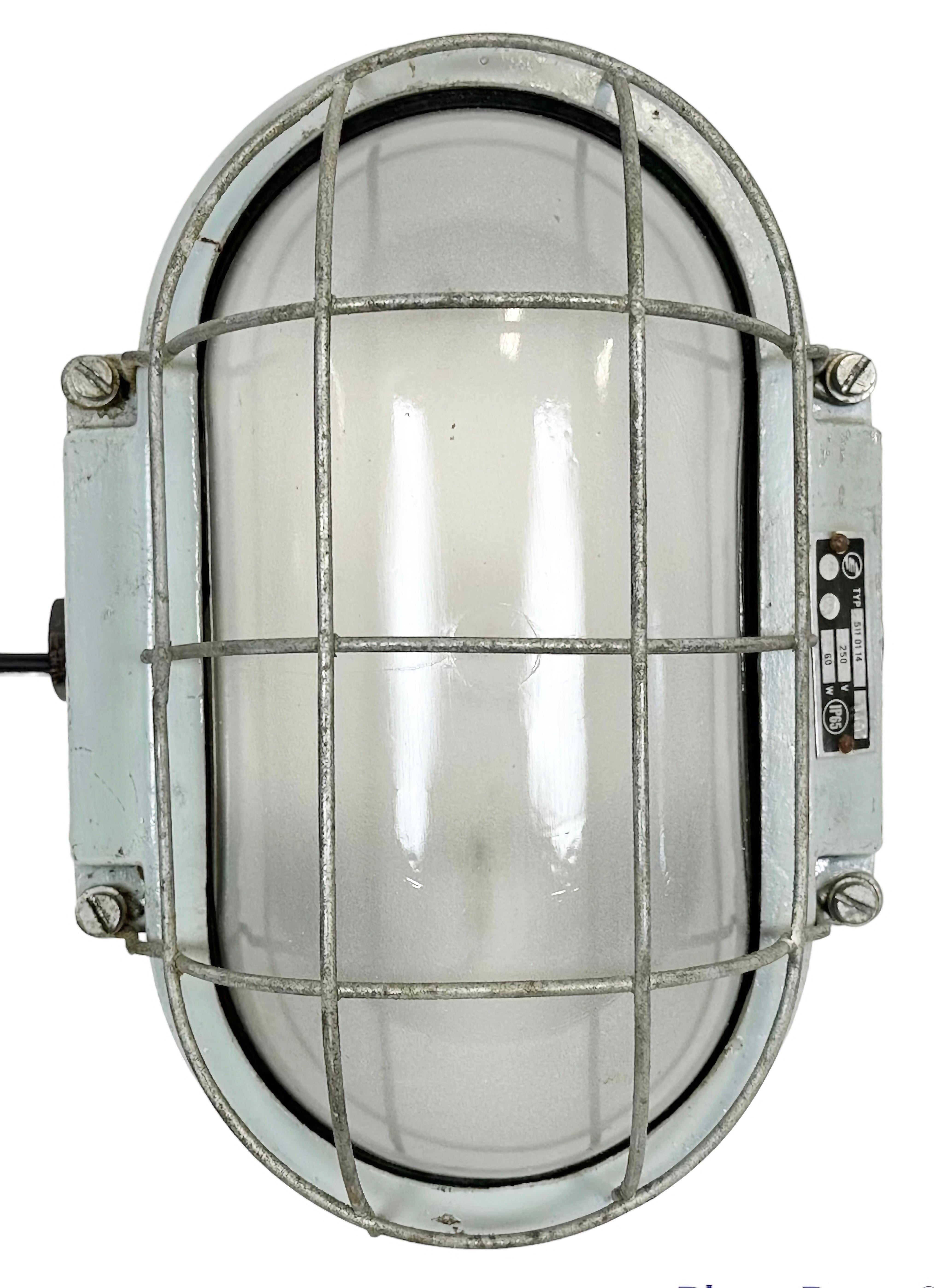 This Industrial wall light was made by Elektrosvit in former Czechoslovakia during the 1970s. It features a cast aluminium body, a milk glass and a steel grid. New porcelain socket requires E 27/ E26 light bulbs. New wire. The weight of the lamp is