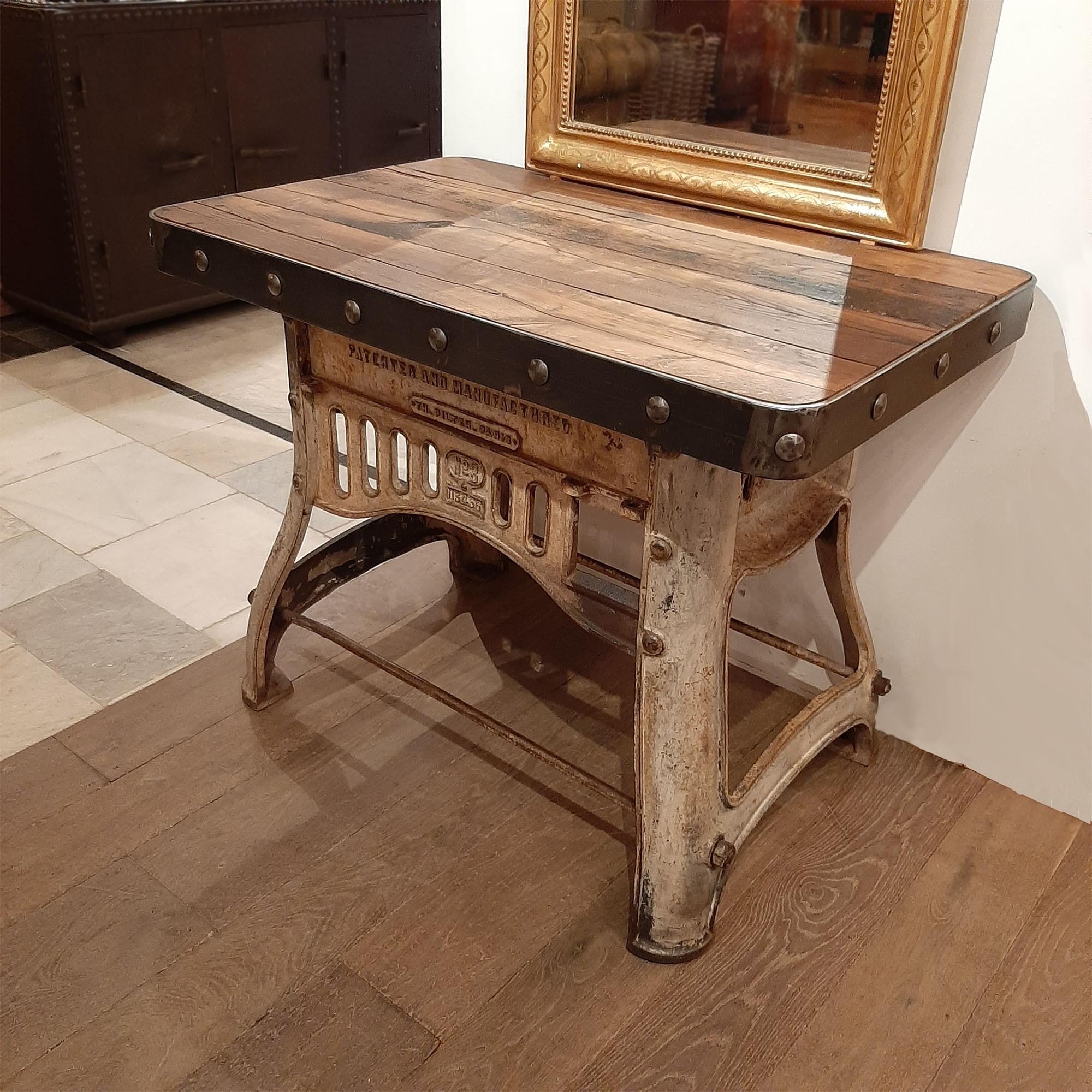 A robust industrial workbench to be used as sidetable or sideboard. This beautiful piece is newly made out of very old industrial materials; an old cast-iron base and a top made of antique oak wagon parts, finished with a sturdy steel