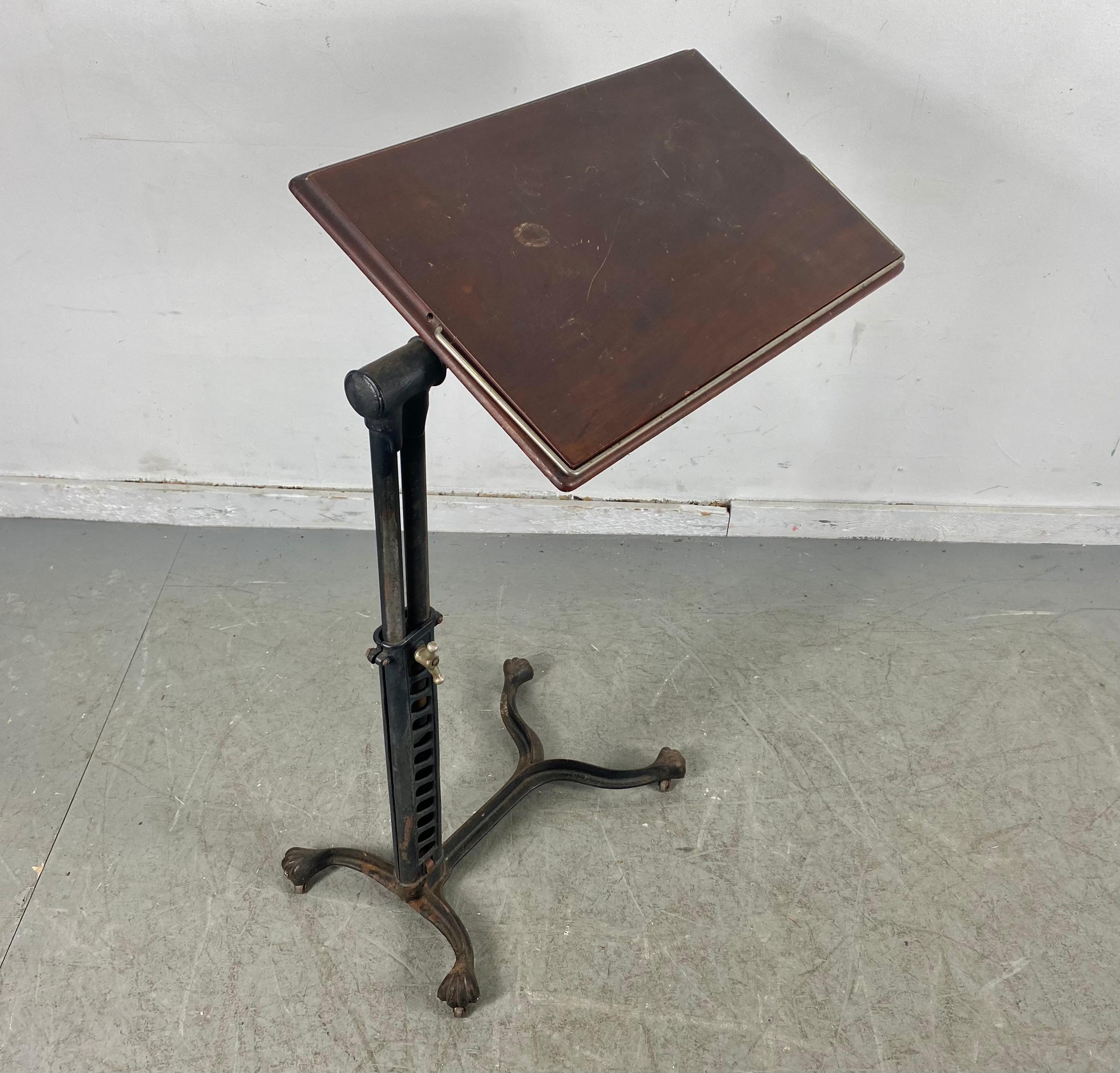 Industrial cast iron and wood adjustable drafting / writing table, unusual mechanism, pierced iron, ball /claw feet, tilt-top, circa 1920s, beautiful design, adjustable height from 26