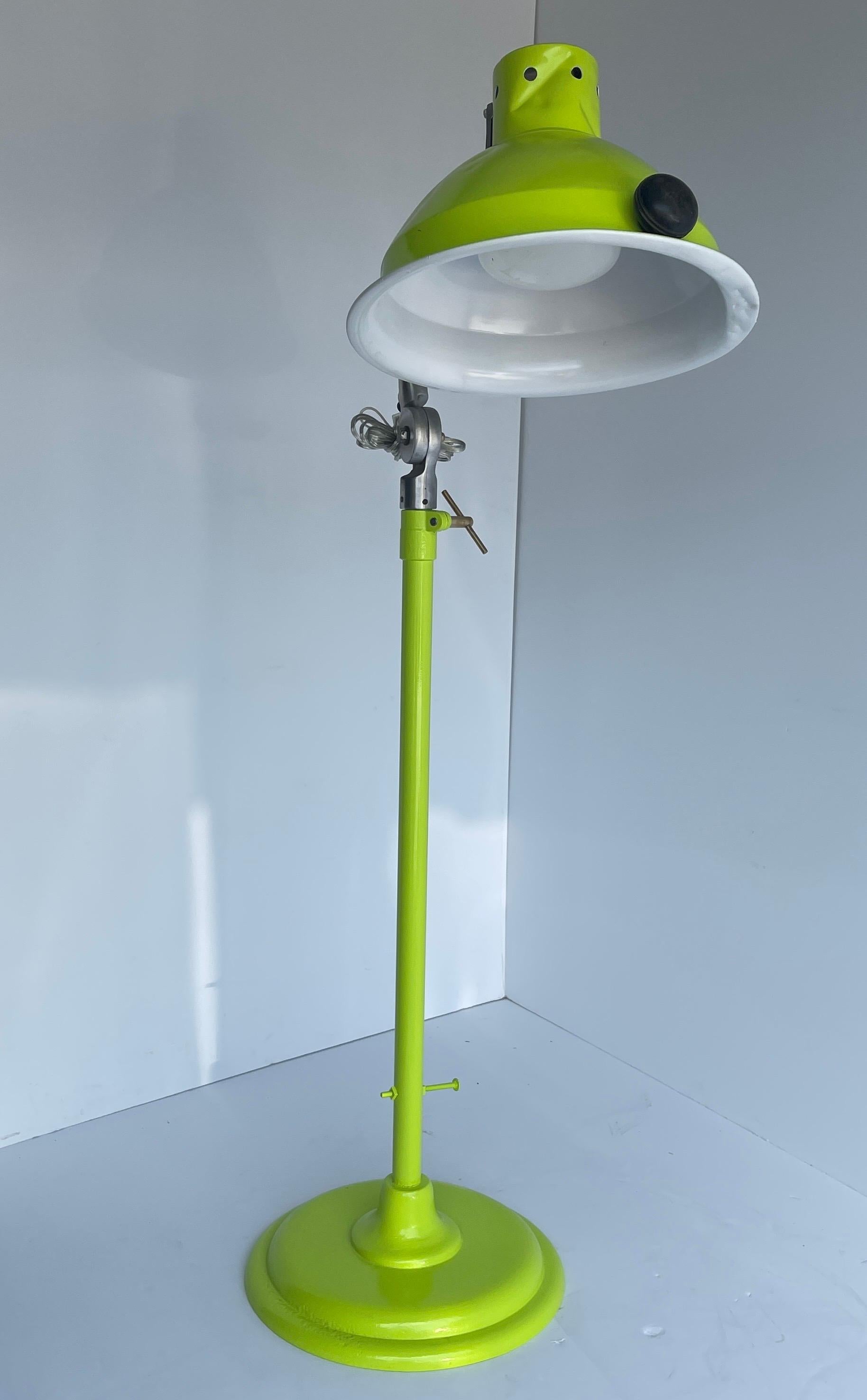 Adjustable Industrial iron floor lamp, powder coated in bright chartreuse, manufactured M. Brandt & Son Co.
This tall iron lamp now has a bright chartreuse and white painted surface. The floor lamp has a brass twist for adjusting shade and working