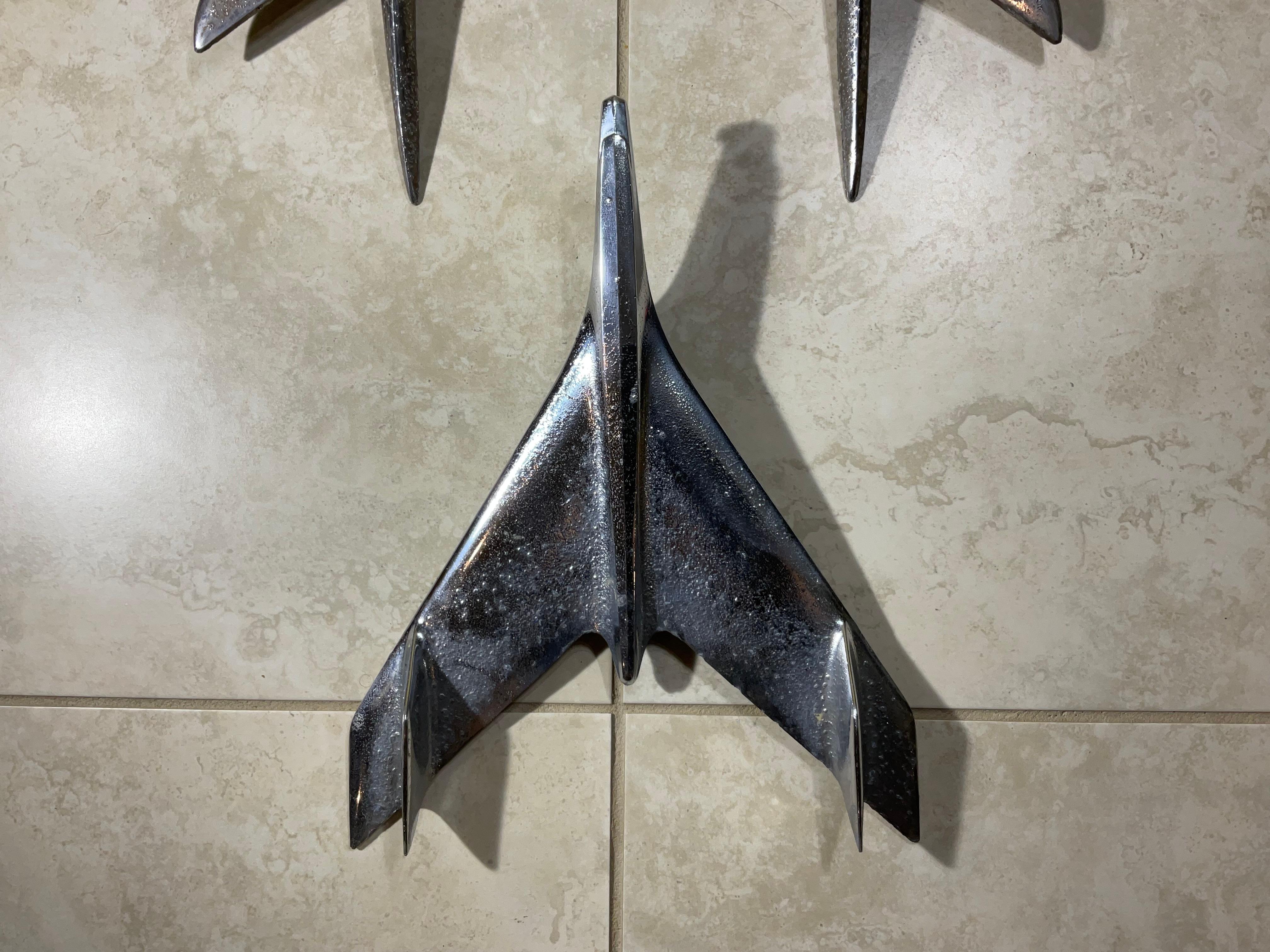 

Transform your space with this unique and eye-catching industrial chic wall art! This stunning three-piece metal wall hanging is crafted from 1950-1956 American car hood ornaments  breathing new life into vintage art pieces  that adding a touch of