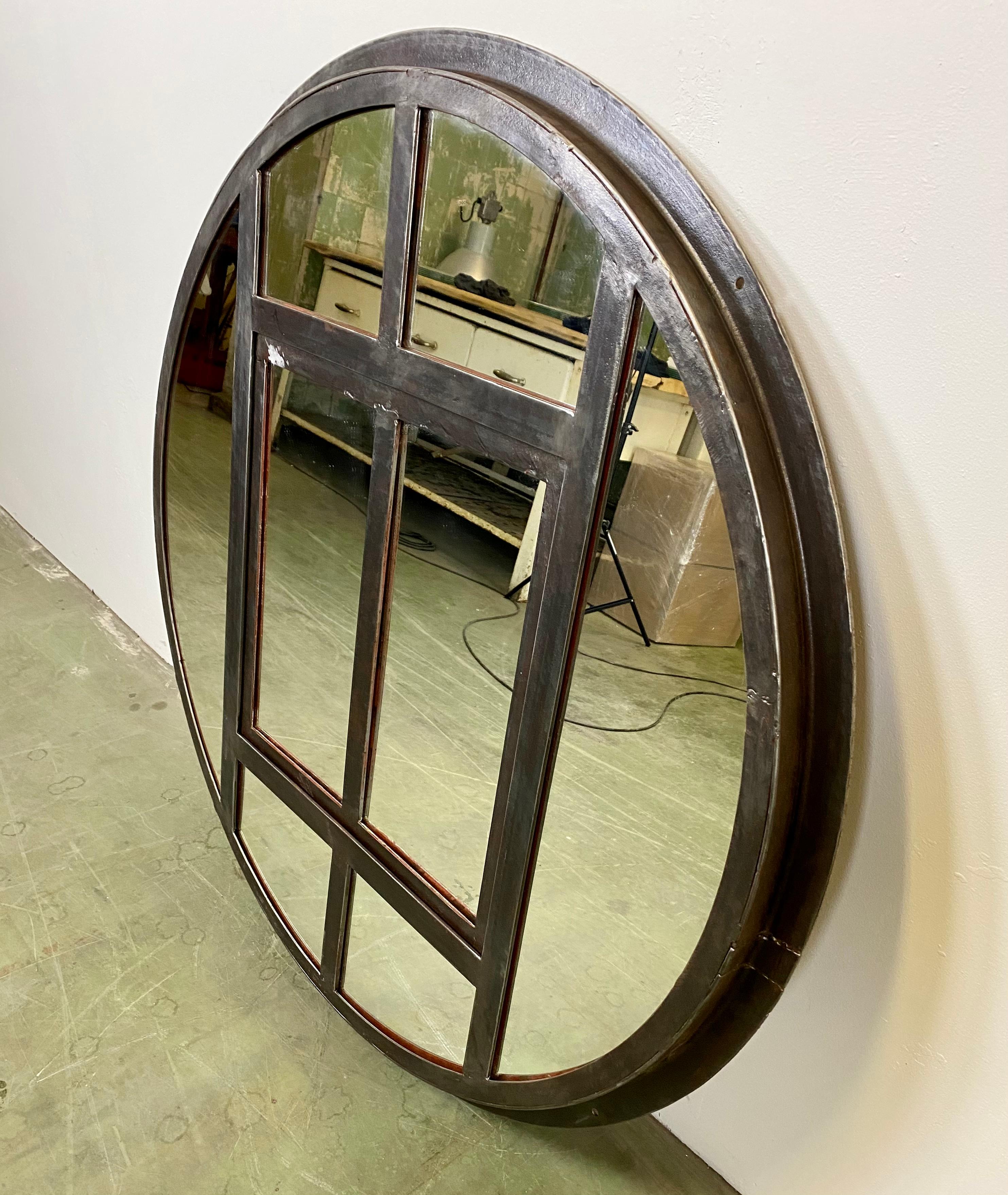 Circle iron industrial window frame has been transformed into a mirror. The weight of the mirror is 45 kg. The diameter of the mirror is 111 cm.