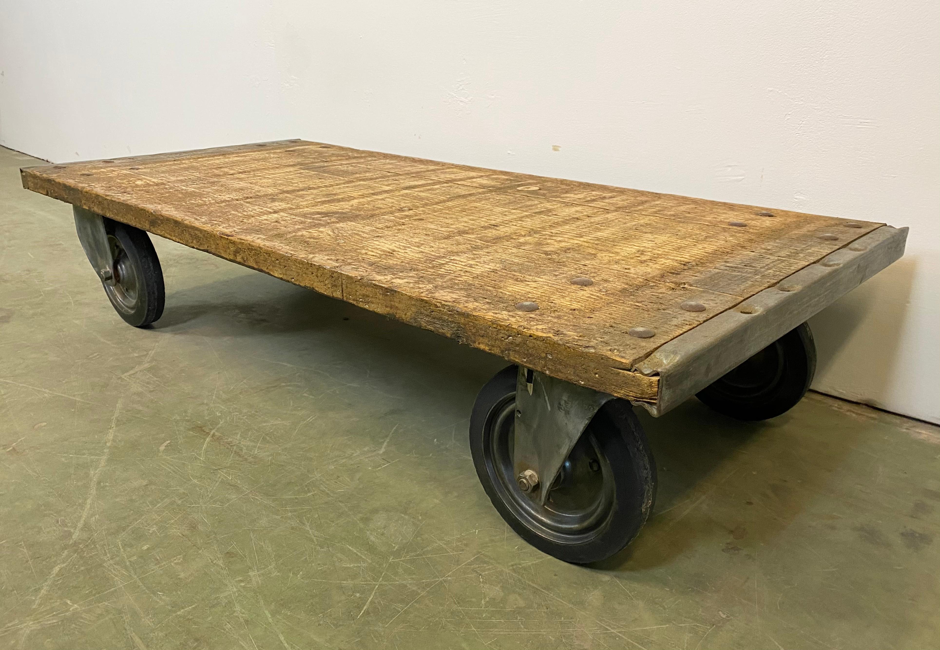 Industrial coffee table from the 1960s. It features four original wheels and solid wooden plate with nice patina. The weight of the table is 30 kg.